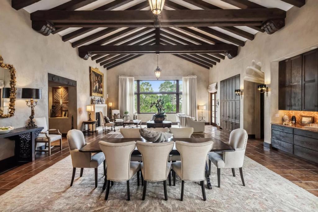 Nestled within walking distance of The Lodge at Pebble Beach, this magnificent Spanish-style estate radiates timeless elegance and unmatched sophistication. From the moment you arrive, the gated entrance welcomes you to a stunning pavered driveway bordered by limestone walls, setting the tone for unparalleled luxury and privacy. Inside, the great room is nothing short of breathtaking, featuring Venetian plaster walls, soaring 25-foot cathedral ceilings, and hand-hewn exposed beams that echo old-world craftsmanship. Every detail is curated with meticulous care, from the fluted niches and custom iron light fixtures to the glazed decorative tile flooring. Built in 2004, this single level, 4-bedroom, 3.5-bath residence offers all the modern luxuries one could desire: radiant heating, a central vacuum system, and a generator for added convenience. The home also boasts a private office, along with a 600-bottle, climate-controlled wine room for the discerning collector. Outdoors, a personal putting green and a tranquil patio complete with a fire pit and fountain invite relaxation and entertainment. This estate is a perfect marriage of classic architectural beauty and modern amenities, ensuring its legacy for generations to come.