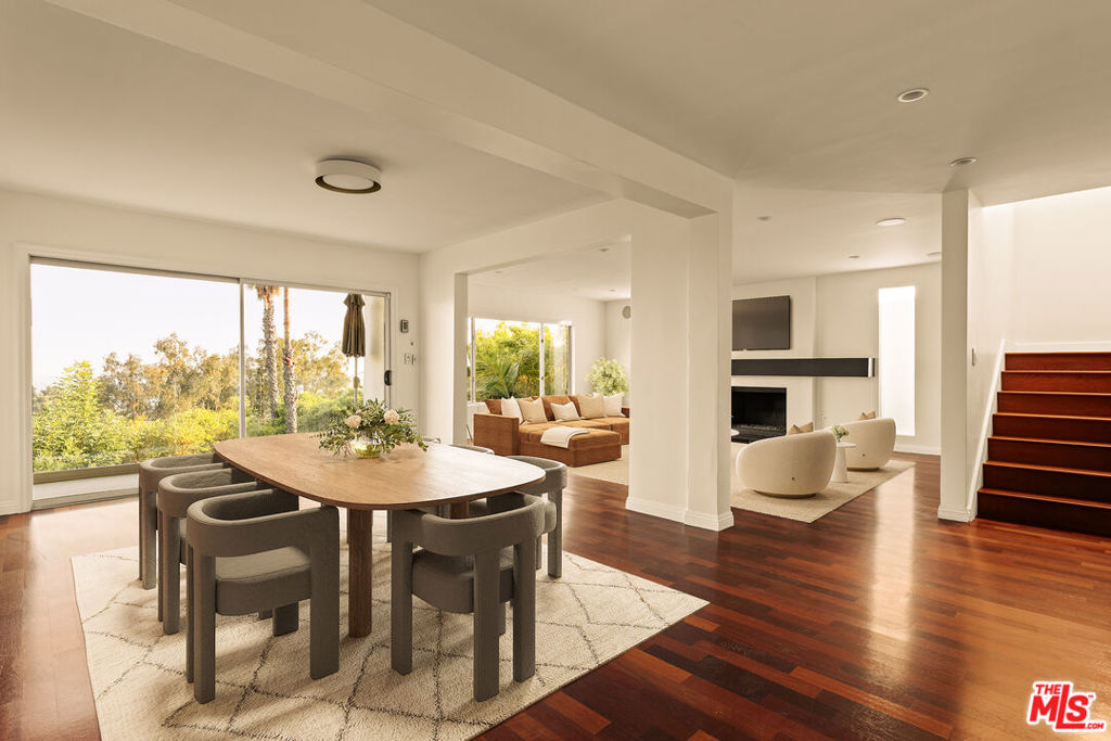 Perched above the city with incredible skyline views, 6350 Bryn Mawr is a 4-bedroom, 2.5-bath contemporary retreat offering both privacy and style. The home opens to a light-filled main level where expansive windows showcase the sweeping vistas. Designed for effortless entertaining the home flows from a bright Italian-designed eat-in kitchen complete with stainless steel appliances, wine fridge, and generous counter space, into the dining area and living room, where a cozy fireplace and balcony frame the stunning vistas. The expansive primary suite features a spa-like bath, walk-in closet, and private patio with even more breathtaking views. Downstairs, three light-filled bedrooms and a charming reading nook with floor-to-ceiling bookshelves provide inviting spaces for relaxation. Outdoors, an entertainer's paradise awaits with a private pool, grill, and multiple seating areas. A fully redone garage and spacious driveway offer ample parking, all just moments from Hollywood Lake, Beachwood Cafe, scenic trails, and Franklin Village.
