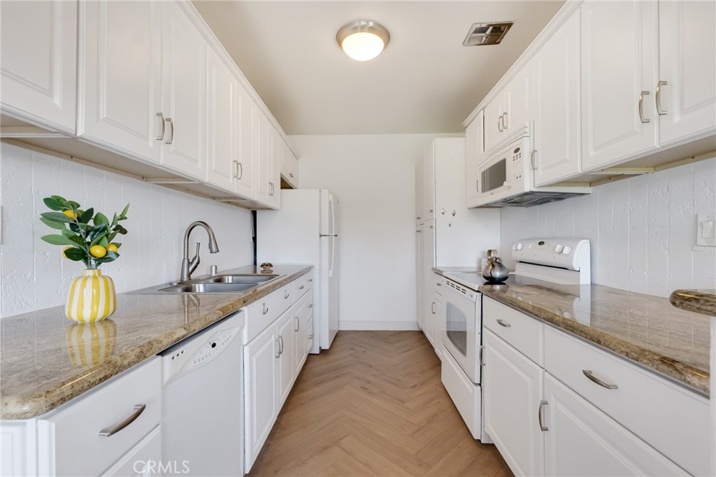 Welcome to this beautifully maintained and light-filled 1-bedroom, 1-bathroom condo located in the heart of Encino. Offering 731 sq ft of comfortable living space, this charming unit features an open and inviting floor plan with laminate flooring, central AC, and ample storage throughout. The spacious living room opens to a private balcony overlooking the peaceful, landscaped courtyard—perfect for relaxing or enjoying your morning coffee.
The galley-style kitchen is equipped with granite countertops, clean white cabinetry and well-kept appliances. The generously sized bedroom offers a deep walk-in closet, while the full bathroom is clean and well-appointed. This well- maintained community offers resort-style amenities including a sparkling pool, spa, gym, and secure entry. One covered parking spot and extra storage are included. Don’t miss this rare opportunity to own a stylish top-floor corner unit in one of Encino’s most desirable neighborhoods!