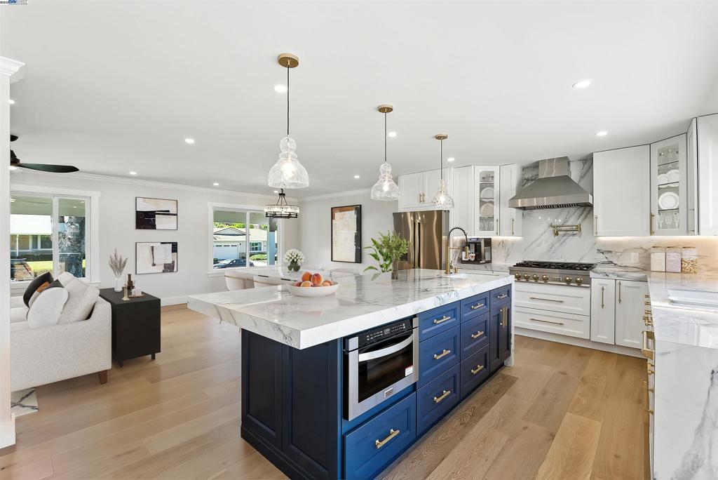 Tucked away in the prestigious Dana Farms neighborhood of Concord, nestled between Clayton & Walnut Creek, this exquisitely reimagined 4 bedroom, 2.5 bath residence offers over 2,000 square feet of magazine-worthy living. At the heart of the home, a bespoke chefs kitchen stuns with a dramatic 9-foot island with porcelain waterfall countertop, sleek custom cabinetry, & premium finishes that balance form & function with effortless grace. The bathrooms reflect modern luxury at its finest, showcasing striking tilework, LED mirrors, sleek vanities with porcelain countertops, & high-end rain showers - including a spacious walk-in double shower in the primary ensuite. Throughout the home, engineered hardwood flooring, Milgard windows, & carefully selected fixtures elevate every room. Behind the scenes, essential infrastructure has been meticulously upgraded, including a 400-amp electric panel, copper plumbing, a tankless water heater, & a finished garage with epoxy flooring. The expansive 1/3 acre+ lot offers more than just curb appeal - enjoy generous side access for an RV & boat, all while surrounded by scenic Mt. Diablo views, hiking trails, & access to the sought-after Northgate High. Luxury like this is rarely so attainable. Welcome to the lifestyle upgrade you've been waiting for.