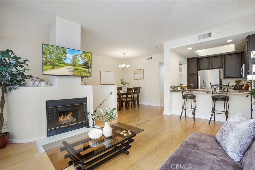 INVITING 2-BEDROOM CONDO IN THE DESIRABLE GATED COMMUNITY OF SUMMIT RENAISSANCE! This beautifully updated 2-bedroom, 2-bathroom condo offers 1,014 sqft of modern comfort and a unique layout that blends style with functionality. Fresh paint, newer bamboo flooring, and large windows fill the home with natural light, while all-new appliances add a touch of luxury. The main living space features an open-concept kitchen that flows seamlessly into the living and dining rooms, creating a warm, inviting space perfect for both everyday living and entertaining. Your kitchen shines with elegant wood cabinetry, stylish finishes, ample counter space, a breakfast bar for casual dining, and even a built-in wine cooler—ideal for hosting. The living room features a cozy fireplace and just beyond, glass sliding doors open to your own private balcony—perfect for enjoying fresh air, morning coffee, or evening relaxation. Down the hall is a spacious primary suite offering a serene escape and a second bedroom/office, while both bathrooms feature contemporary, spa-like upgrades. This gated community offers resort-style amenities including a sparkling pool, spa, gym, workout area, and picnic spots. Direct access to your tandem two-car garage provides ample parking and storage. Ideally located near Weir Canyon Nature Preserve, popular supermarkets such as Costco and Target, grocery stores, restaurants, shopping centers, and with easy access to major freeways for convenient commuting. Don’t miss your chance to own this stunning multi-level home in a vibrant, sought-after neighborhood. Schedule your private tour today!