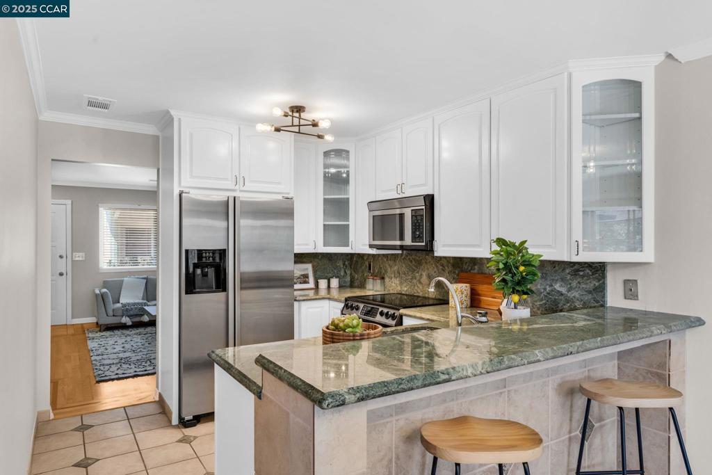 Charming Townhome with Custom Upgrades & a Gardener’s Paradise! Explore this well-maintained single-story townhome, conveniently located within 4 miles of Pleasant Hill / 680 freeway and Concord BART—ideal for those looking to downsize or escape high city prices. Inside, enjoy elegant ¾” hardwood maple flooring with cherry wood inlays, crown molding, and dual-pane windows that bring in natural light. The kitchen features stunning Costa Esmeralda granite countertops, Italian porcelain tile, and modern appliances, including a refrigerator, oven, microwave, flat cooktop, and dishwasher. The primary suite includes a remodeled bathroom and a walk-in closet, while all bedrooms offer mirrored closet doors. The fenced backyard (new fence from 3 years ago) is a gardener's dream, featuring; A caged area with mature organic blueberry bushes and a watering system; A dismantlable plant starter area and a hanging garden for climbing plants. Additional highlights include a hydroponic grow room in the garage, an ADT security system and ample parking with a 2-car driveway and detached 1-car garage. This unique find is perfect for gardeners, families downsizing, or buyers seeking suburban value—offering a low-maintenance lifestyle with thoughtful upgrades, ready for you to move in and grow.