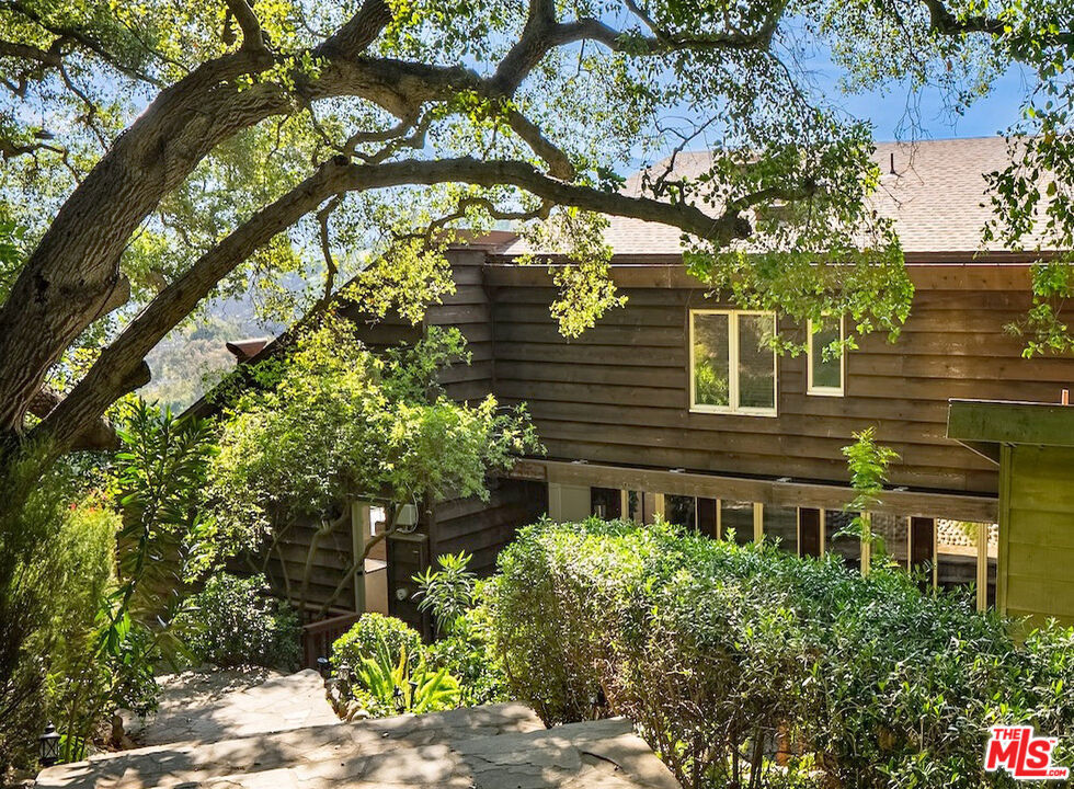 Perched atop a private road on one of Topanga's most coveted streets, 21338 Colina Drive offers breathtaking southern canyon views and effortless access to scenic park trails. This spacious 4-bedroom, 3-bathroom main home boasts an open-concept living room with soaring vaulted ceilings, rich hardwood floors, and a dramatic wall of glass that showcases expansive canyon vistas. The heart of the home is the true chef's kitchen, equipped with top-of-the-line appliances, ideal for entertaining or preparing intimate meals. The luxurious primary suite features a walk-in closet and a serene soaking tub for ultimate relaxation. Two additional bedrooms offer comfort and versatility, while a spacious family room functions perfectly as a second primary suite. Additionally, a cozy den makes an ideal home office, creative space, or reading nook. A private entrance leads to a charming 1-bedroom, 1-bathroom studio guesthouse with a kitchenette, perfect for studio for guests, extended family, or an office.. The home is encircled by expansive decks, offering the perfect setting to relax, dine, or entertain while taking in the captivating canyon views. With its prime Topanga location, spacious floor plan, flexible living spaces, and exceptional outdoor areas, this remarkable home is available for move-in starting April 15.