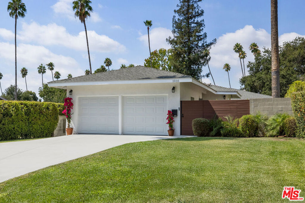 In Pasadena's coveted Washington Square, this 1956 residence delivers space, privacy, and a massive yard on an oversized lot. Large windows fill the expansive great room with light, highlighting wood floors; charming wallpaper moments add character throughout the home. The kitchen is outfitted with stainless appliances and generous storage, a warm space for cooking and entertaining. Four large bedrooms provide versatility for life and work, with options for a home gym or office; two baths and a powder are finished with period style. French doors connect the interior to green spaces, with grassy back and side yards offering serene settings for al fresco gatherings of any scale. Enjoy central heat + air, washer/dryer, and a roomy two-car garage. Set on a tree-lined street, you're close to local favorites Roma Market, Woon Pasadena, Millie's, and Lavender & Honey, with Trader Joe's and Erewhon a short hop away on Lake Ave.