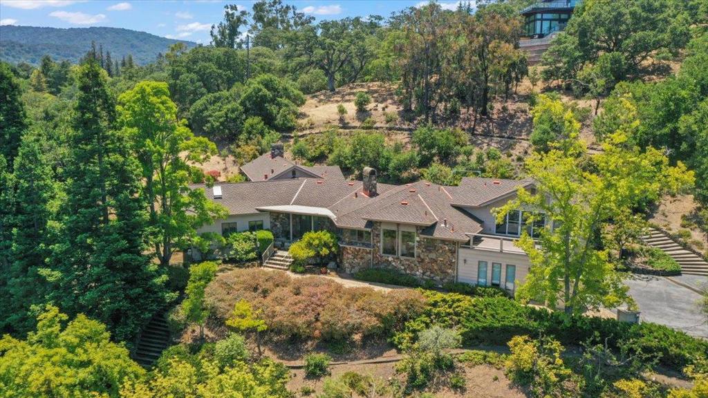 Nestled in prestigious Los Altos Hills this 5Br, 3.5Ba home offers unparalleled blend of luxury and privacy. This home offers the best of both worlds: a private, idyllic retreat surrounded by nature yet close to the vibrant downtown Los Altos. Enjoy easy access to top-tier schools, premier shopping and dinning, all within a coveted community known for its exclusivity and charm. Some of the amenities include large primary bedroom with spa like bath just a few steps away from kids bedrooms. Additional bedrooms with private baths. Floor to ceiling windows and oak hardwood floors creating a warm and refined ambiance. Chefs kitchen with stainless appliances, sub zero and amazing views of the hills. Expansive living spaces with multiple fireplaces, perfect for large families to play and entertain. Versatile Spaces: Private office or game room with spectacular view deck could be the 6th bedroom. Large yard for entertainment with great potential with multiple sitting areas and trail going up the hill to amazing views. Large 3 car garage with ev charger and storage room.