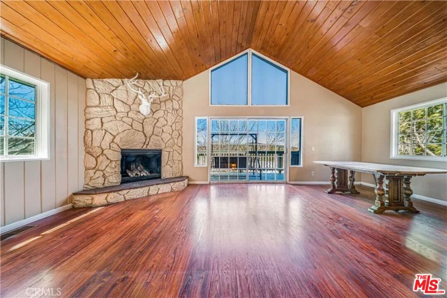 This inviting Lake Arrowhead home combines breathtaking mountain views, spacious living areas, and exclusive lake rights for year-round recreation. The main level boasts an open-concept design with vaulted wood-beamed ceilings, expansive windows that fill the space with natural light, and a classic rock fireplace for cozy mountain evenings. The kitchen and dining area seamlessly connect to a large deckperfect for entertaining or relaxing in the crisp mountain air. The lower level features three spacious bedrooms, two bathrooms, and an indoor laundry area for everyday convenience. Multiple outdoor seating areas offer ideal spots for morning coffee, al fresco dining, or unwinding under the tall pines. Enjoy the best of Lake Arrowhead living with easy access to the lake, hiking trails, and local shopsmaking this home the perfect retreat for all seasons.