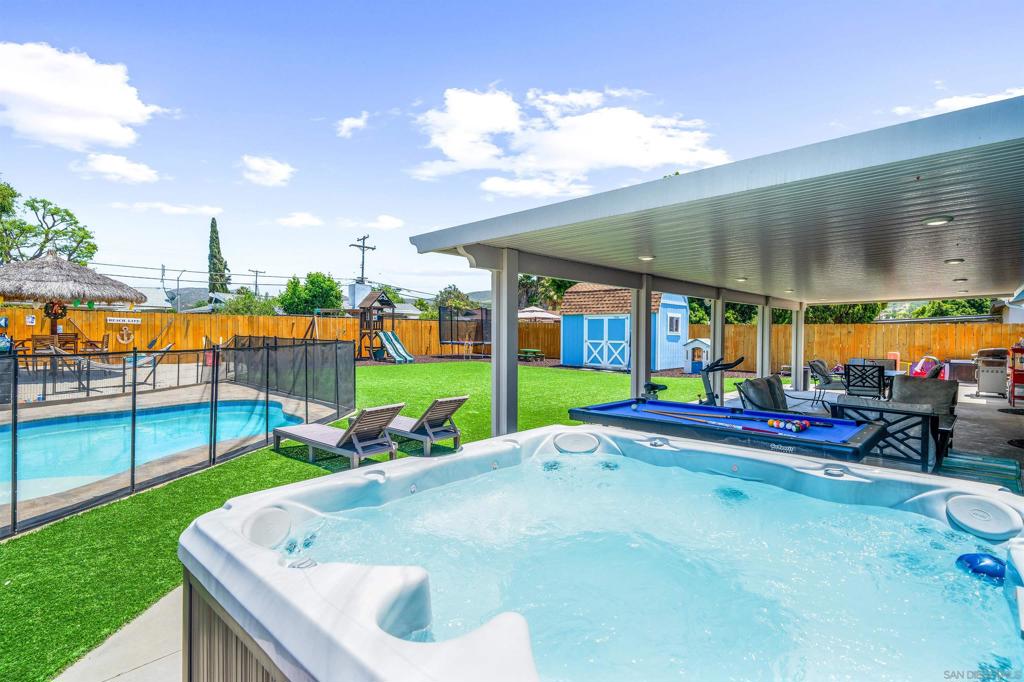 Designed for year-round enjoyment, the backyard is a true retreat featuring a sparkling pool, tropical beach with palapa, turf, custom playground space, storage shed, and spacious covered patio with seamless indoor-outdoor flow. The open-concept interior is filled with natural light and offers a flexible layout ideal for entertaining or relaxing. Don't let the SF fool you- this home feels way bigger with the all season patio. Located on a cal de sac in a great neighborhood within the award-winning Poway Unified School District. No HOA. RV/Boat parking. Easy to add-on or build and ADU.