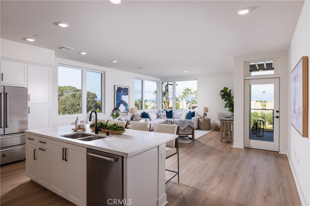 A modern masterpiece in the world of condominiums, this exceptional residence is located in the prestigious ShoreHouse of downtown Huntington Beach. With an open-concept layout that blends functionality with stunning aesthetics, this home offers the perfect balance of style and comfort. Upon entry, you are greeted by a formal foyer that flows seamlessly into the expansive great room, featuring a chef-inspired kitchen with light-veined quartz countertops, top-of-the-line Bertazzoni appliances, under-cabinet lighting, and a large island with bar seating. The kitchen opens to the dining and living areas, which boast 10' ceilings and oversized windows, creating an open, airy ambiance throughout the luxury space.
A thoughtfully designed in-home laundry room with a sink and counters is conveniently located near the entry, separate from the living and sleeping quarters. The serene primary suite features dual closets, a dual vanity, and a frameless glass shower adorned with custom designer tiles and finishes. Enjoy the serene, tree-lined, and rooftop views from the expansive private balcony off the living room, perfect for relaxing during those special outdoor moments.
The building offers a host of premium amenities, including a rooftop terrace with breathtaking pier and ocean views, an indoor bike storage room, a beach storage room with a shower, underground dedicated parking with electric car charging, and a lobby with a mail room. Immerse yourself in the vibrant downtown Huntington Beach lifestyle, with easy access to shopping, dining, events, and water sports competitions. Whether you're enjoying air shows, fireworks displays, parades, concerts, or simply relaxing on the sand in perfect weather, this one-of-a-kind condo puts you at the heart of it all.