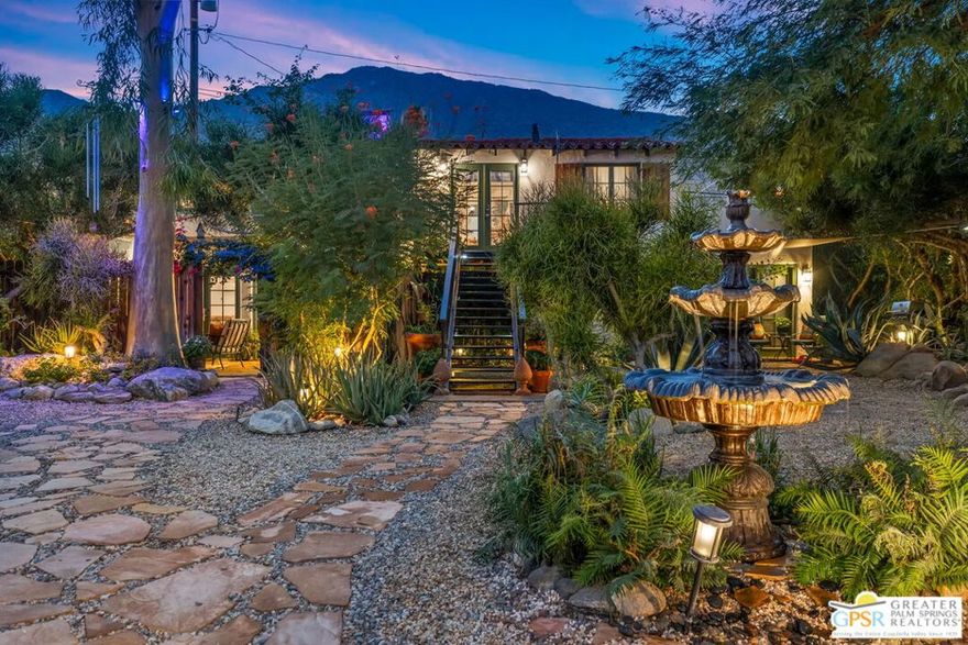 Built in 1936, this Spanish Colonial Style Ranch carries a rich and colorful history that captures the spirit of old Palm Springs. Once known as Casita de Sueos, it served as a Hollywood-inspired haven for the Los Compadres riding club and a lively meeting place for the cowboy culture of the 1930s. Horses from the famed El Mirador and The Desert Inn hotels once roamed here, and in later years, the property housed horses for the Palm Springs Police Department. During the mid-century era, it became a creative refuge for artists, including local surrealist painter Snake Jagger, and was beloved by the desert's thriving artistic community of the 1960s and 1970s. Set within a private gated enclave surrounded by stunning landscaping, this upper residence spans 1,278 square feet and offers two bedrooms and one bath. The home has been beautifully remodeled to blend timeless design with modern comfort, featuring new mini split systems throughout for personalized heating and cooling. Inside, natural light pours through large windows, framing picturesque mountain views and lush greenery. The kitchen is a thoughtful blend of character and function, featuring butcher block counters, glass-front cabinetry, and warm textures that echo the home's Spanish heritage. French doors open to a private terrace, where you can enjoy morning coffee or unwind beneath the palms as the sun sets behind the San Jacinto mountains. The grounds surrounding the home are truly extraordinary, lovingly curated by an owner with a passion for the desert landscape. Mature palms, flowering plants, and winding stone pathways create a setting that feels both peaceful and alive. The gardens are a living work of art, offering the perfect balance between serenity and vibrancy. Available furnished or unfurnished, this residence embodies everything that makes Palm Springs special: a timeless sense of style, rich history, and an intimate connection to the beauty of the desert.