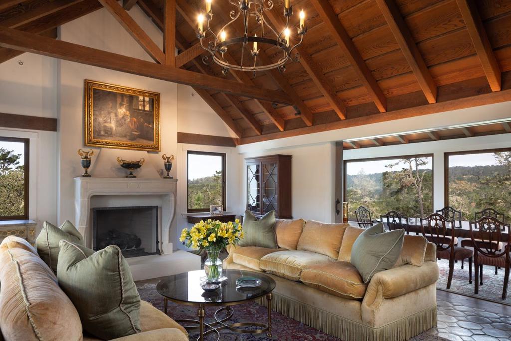 Lovely, remodeled home in quiet section of Carmel Woods perched above the forest with long vistas - ocean view from some windows as well. Large living room with high beamed ceilings, a beautiful fireplace and hardwood floors, which are also throughout the entire main level. Dining room is oversized with tons of windows and views of the ocean. High quality kitchen with marble counter tops open to a family room with fireplace and access to the decks. Bookshelves line the library which could also be used as a fourth bedroom as it adjoins a full bath. Upstairs from main level are two bedrooms with vaulted ceilings and a full bath to share. Downstairs from the main level is the large primary suite with a fireplace, private patio and a large primary bath with shower and separate tub. In addition, there is an office and an amazing stone wine grotto.