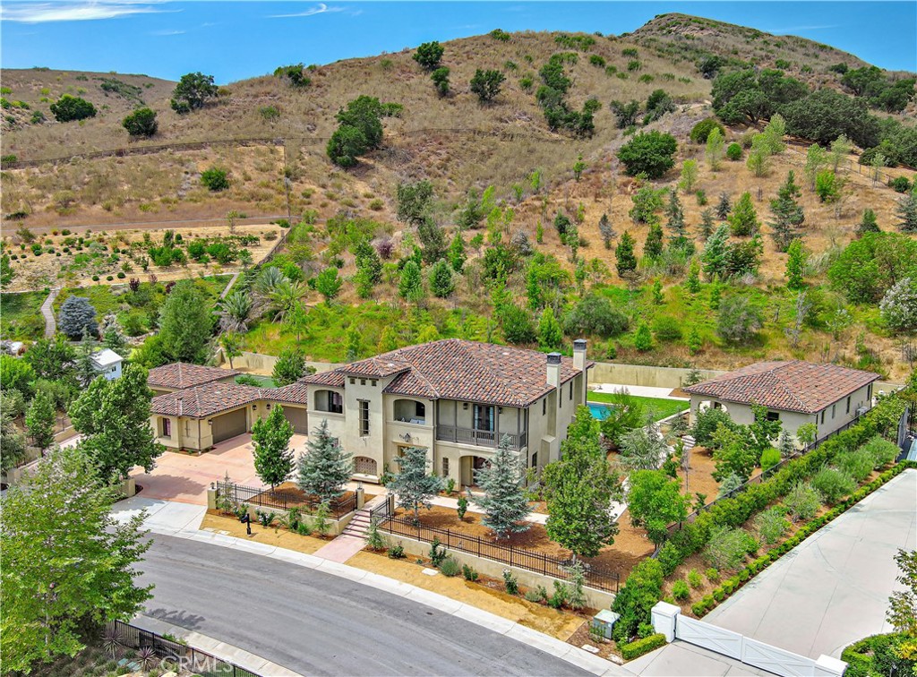 Stunning Mediterranean estate in a small gated, quiet community. Built in 2019, this remarkable home sits on 3.6 acres of opulent beauty and privacy, surrounded by tranquil hillside vistas.
The main residence is a two-story masterpiece offering four bedrooms and five bathrooms, plus a dedicated home office. Every bedroom includes its own en-suite bathroom, and the property showcases exceptional craftsmanship with top-of-the-line finishes throughout. The gourmet chef’s open kitchen features high ceilings and premium appliances, creating an ideal space for entertaining and daily living.
This estate also includes a separate Casita with one bedroom and one bathroom, and a private guest house composed of two bedrooms, two bathrooms, a full kitchen, and a sauna. (Included in bed/bath count and total square footage.)
For car enthusiasts, there is a five-car garage with ample additional parking. The outdoor living is equally impressive, with an expansive backyard designed for entertaining, a large pool, a spa/jacuzzi, and a sports court. The serene hillside surroundings provide a tranquil and private retreat.
This property features impeccable materials and finishes throughout and represents a rare opportunity to own a luxury Mediterranean estate in a sought-after gated community. Don’t miss the chance to explore this exceptional residence.