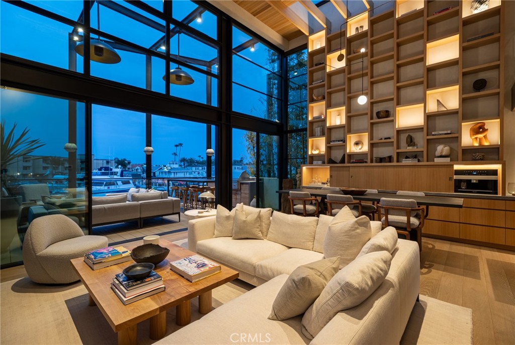 Introducing 2910 Lafayette Avenue - a newly completed architectural statement on the bayfront in Newport Beach’s sought-after Cannery Village. Designed and constructed over several years with unwavering precision, this bespoke residence reflects the craftsmanship and curated materials typically reserved for world-class superyachts. Offered now for the first time, it is a singular home that elevates coastal living into an art form. From the street, the residence is quietly bold—an exercise in restraint and proportion, seemingly hidden in plain sight. Step inside and the home opens to a soaring sanctuary of light, volume, and detail. Designed in collaboration with renowned interior designer Ohara Davies-Gaetano, the interiors showcase a masterful use of slatted white oak paneling, hand-troweled plaster, soft stone underfoot, and curated lighting—an inspired juxtaposition of texture and tone. Disappearing walls of glass by Otiima frame stunning harbor views, while the chef’s kitchen centers around a sculptural leathered-stone island, with concealed pantry and integrated Thermador appliances. Upstairs, a floating terrace features a full al fresco kitchen with BBQ, sink, fridge, and ample space for entertaining under watercolor skies. A private elevator accesses all levels, including a secure three-car garage. The upper floors offer two serene bedrooms, including a primary suite with spa bath and hidden wardrobe wall, as well as a finely detailed penthouse lounge with panoramic harbor views. Below, a flexible bayfront gallery features a wine wall, beverage center, AV system, and two hidden Murphy beds—opening to your private dock slip (accommodates 31-ft boat) and sculptural outdoor shower. Located steps from Lido Marina Village’s cafes, boutiques, and markets, 2910 Lafayette is the realization of a deeply considered vision—executed with the precision of a fine Swiss watch. A rare offering for those unwilling to compromise.
