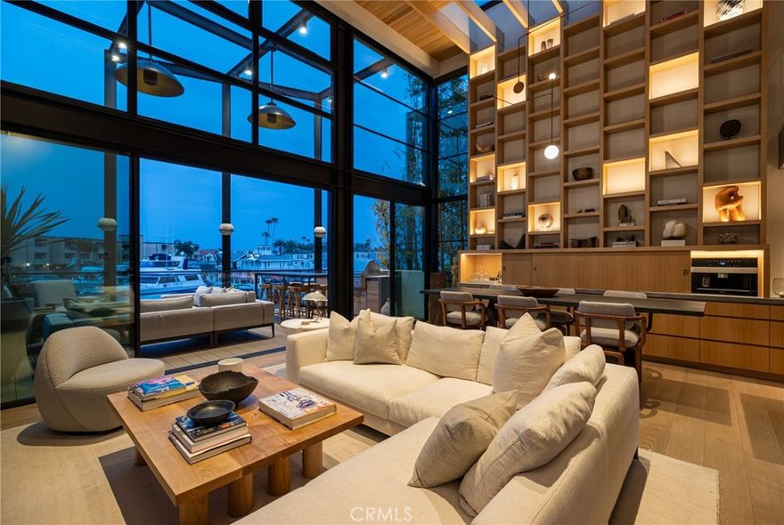 Introducing 2910 Lafayette Avenue - a newly completed architectural statement on the bayfront in Newport Beach’s sought-after Cannery Village. Designed and constructed over several years with unwavering precision, this bespoke residence reflects the craftsmanship and curated materials typically reserved for world-class superyachts. Offered now for the first time, it is a singular home that elevates coastal living into an art form. From the street, the residence is quietly bold—an exercise in restraint and proportion, seemingly hidden in plain sight. Step inside and the home opens to a soaring sanctuary of light, volume, and detail. Designed in collaboration with renowned interior designer Ohara Davies-Gaetano, the interiors showcase a masterful use of slatted white oak paneling, hand-troweled plaster, soft stone underfoot, and curated lighting—an inspired juxtaposition of texture and tone. Disappearing walls of glass by Otiima frame stunning harbor views, while the chef’s kitchen centers around a sculptural leathered-stone island, with concealed pantry and integrated Thermador appliances. Upstairs, a floating terrace features a full al fresco kitchen with BBQ, sink, fridge, and ample space for entertaining under watercolor skies. A private elevator accesses all levels, including a secure three-car garage. The upper floors offer two serene bedrooms, including a primary suite with spa bath and hidden wardrobe wall, as well as a finely detailed penthouse lounge with panoramic harbor views. Below, a flexible bayfront gallery features a wine wall, beverage center, AV system, and two hidden Murphy beds—opening to your private dock slip (accommodates 31-ft boat) and sculptural outdoor shower. Located steps from Lido Marina Village’s cafes, boutiques, and markets, 2910 Lafayette is the realization of a deeply considered vision—executed with the precision of a fine Swiss watch. A rare offering for those unwilling to compromise.