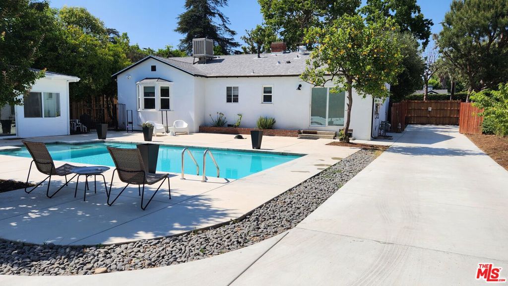 Welcome to your private resort-style retreat in the heart of Valley Glen, located on an extraordinary 16,500 sq ft corner lot at Greenbush and Erwin. This beautifully remodeled 3-bedroom, 2.5-bathroom home offers a rare blend of space, design, privacy, and lifestyle amenities, in one of the San Fernando Valley's most desirable residential pockets. Step inside to a bright, open-concept floorplan where the open kitchen overlooks the living and dining areas, creating a seamless flow ideal for both entertaining and everyday living. The living room is centered around the fireplace. The home features new flooring, recessed lighting, and updated finishes throughout. The spacious primary suite is a true sanctuary, with a spa-inspired bathroom that includes dual walk-in showers and a luxurious rain shower for a daily spa experience. The outdoor space is nothing short of spectacular. Centered around a large 30' x 17' swimming pool and hot tub, the backyard also features a private pickleball pad, perfect for recreation and entertaining. A detached outdoor casita/pool house with its own fireplace and air conditioning offers endless flexibility. Use it as a guest house, home office, pool cabana, gym, or creative studio. The entire property is enclosed by a tall redwood privacy fence and remote-controlled entry gate, ensuring seclusion and peace of mind. A full 8-camera security system provides full coverage. The detached 2-car garage features a hardwired EV charger and long driveway with ample parking for guests. The home's exterior has been updated with modern stucco, giving it clean appeal and a contemporary finish. The landscaping is a true California dream, with some mature fruit trees including orange, lemon, grapefruit, pomegranate, nectarine, a grapevine, and even a golden berry bush providing seasonal, homegrown produce and a serene garden experience. With R1 zoning and a flat, oversized lot, the property offers excellent potential for future expansion or the addition of an ADU (Accessory Dwelling Unit) for rental income or multigenerational living (buyer to verify all regulations). Located in a tranquil Valley Glen neighborhood. This home is just minutes from Sherman Oaks, Studio City, NoHo West, Ventura Blvd, and convenient freeway access (101, 170, 405). Steps away from Los Angeles Valley College. Enjoy the best of both worlds, a private estate-like setting with easy access to some of LA's best dining, shopping and entertainment. This is a one-of-a-kind property that offers rare amenities, space, and flexibility in a prime location. Move-in ready and designed for indoor/outdoor living, entertaining, and long-term potential. Don't miss your chance to own a unique piece of the Valley!