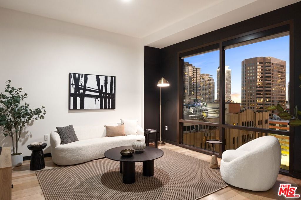 Bold and modern, welcome to a corner loft at the Hope Street Lofts in the Financial District of Downtown L.A. Immediately upon walking in you will be greeted by a formal hallway entrance, tall gallery walls and brand new wood floors. The semi-open floor plan is polished to perfection. The condo renders stunning city views from South and West facing floor-to-ceiling windows/walls. 2 stunning black accent walls add a layer of sophistication. Undeniably stylish custom Hunter Douglas window dressings. The loft features 2 bedrooms with 1 fully enclosed bedroom and 2 full baths. The perfect place to entertain or unwind. The sleek kitchen includes brand new double stacked white cabinetry, brand new backsplash, new stainless steel fridge & dishwasher and an oversized breakfast bar. Two full bathrooms with soaking tubs each. The principal bathroom features luxurious dual vanity sinks, mosaic tile, and a wow-factor spacious walk-in closet with custom shelves. Recessed lights throughout. Washer and dryer in unit. Hope Street Lofts is a boutique art deco condo building with only 80-units. Building amenities include 24/7 security, front desk concierge, a rooftop with panoramic Downtown views, a helicopter pad, sundeck, barbecue grills and a chic wet bar. The rooftop was just redone and new furniture has been ordered. For lifestyle convenience, a game room and gym. Bonus feature: Large storage room in the basement exclusive to this unit. 1 unassigned parking space included - onsite with an elevator bank giving access to the 11th floor as well as the lobby.Located directly above the 7th Street Metro Station, enjoy the best of urban dwelling at your doorsteps. Walk to the action at Crypto Arena or LA Live. Enjoy the best of food and beverages at Javiers or Bottega Louie. Across the street from the Bloc and Joeys. Whole Foods is a stone's throw away and the Broad Museum is within walking distance. Enjoy rich and diverse dining, museums, and entertainment options. Truly, the best location in Downtown L.A.