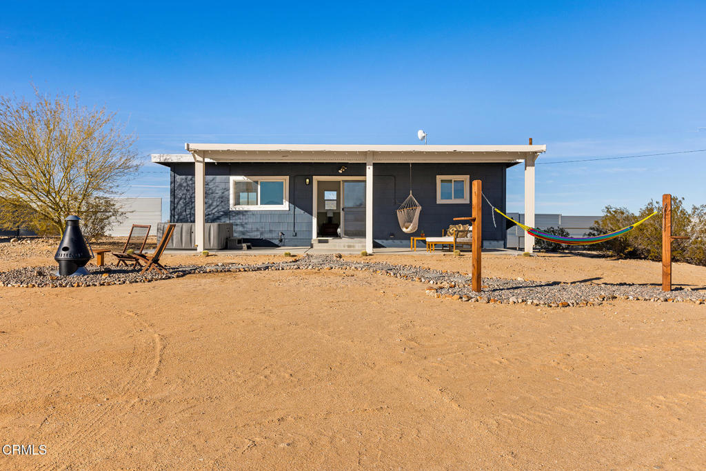 Desert charm meets modern comfort in this airy, open studio on the Copper Mountain Mesa. With sweeping views of Joshua Tree National Park and BLM land directly to the south, 67975 Presswood Rd offers privacy and tranquility with quintessential high-desert vibes. Built in 1959 and beautifully updated, the 592 square foot layout is filled with natural light from five large skylights and connects seamlessly to the outdoors. The previous owners completed a major renovation, converting this former homestead cabin into a Single Family Residence, and the kitchen and bathroom were also remodeled in 2023 with modern finishes and newer appliances, including a stove, refrigerator, and stackable washer/dryer. The open floor plan provides generous space and flexibility, with the potential to convert the layout into a one-bedroom design if desired. Enjoy desert living from the large covered patio--perfect for outdoor dining, stargazing, or soaking in the hot tub under the expansive desert sky. The property also features a fire pit, hammock, and thoughtfully landscaped grounds with desert willow, palo verde, and olive trees on a drip irrigation system. Fully furnished and move-in ready, this inviting desert retreat is ideal as a primary residence, weekend escape, or turnkey investment property.