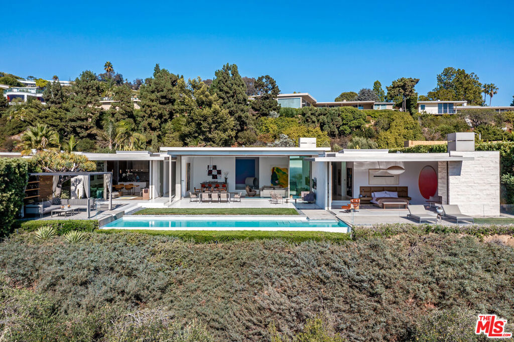 Museum Modern on the Front Row of Trousdale Place. Designed by William Hefner, as an art collector's dream. Sited on a 30,000sqft lot+ with pine forest and unobstructed views to the City and Pacific Ocean. Approx 7,000sqft all one level with high ceilings. Walls of glass open to lawn, infinity edge pool, cabana and vast areas for entertaining. Entrance foyer doubles as art gallery, open concept living/dining space with bar. Gourmet kitchen opens to informal living room and has a discrete prep area. Primary suite offers panoramic views, sumptuous marble bath, large dual closets and fireplace. Additional features include: wood paneled office with bath. Gym, guest suite and staff accommodations. Complete privacy behind gates and motor court. A showplace adjacent to some of the most important estates in the city.