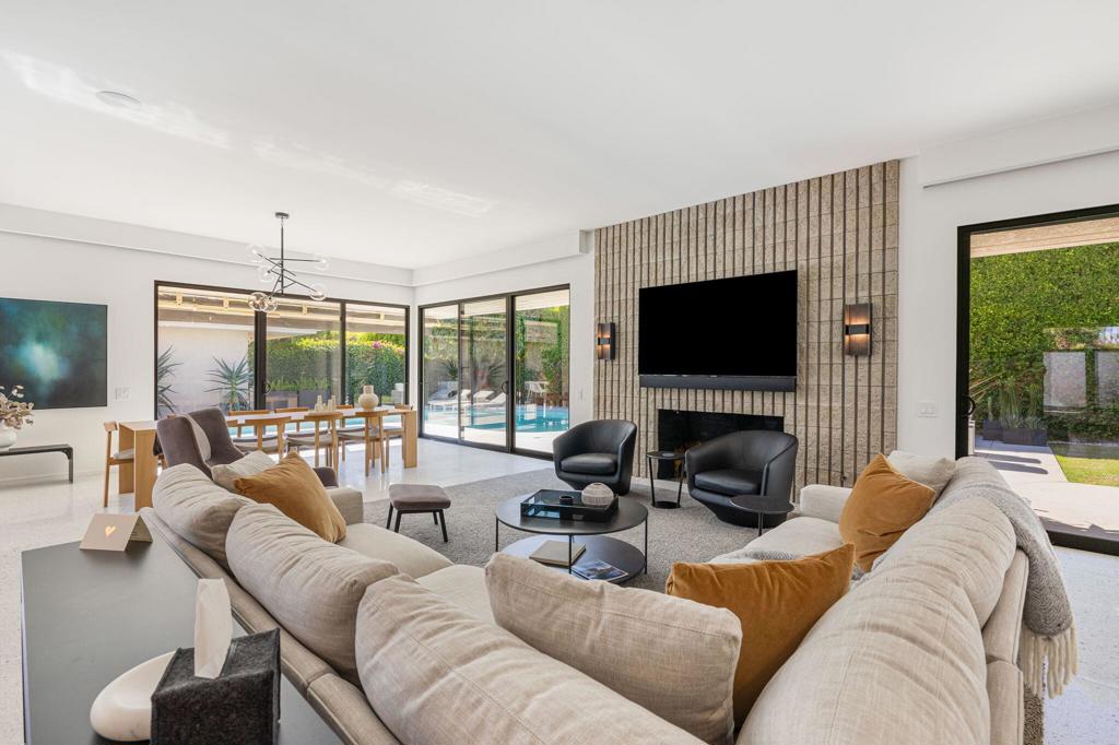 Welcome to this one-of-a-kind redesigned home in The Springs, where modern elegance meets ultimate comfort. The WOW factor starts at the impressive glass pivoting front door, setting the tone for the stunning interior that awaits. Gather your friends and family around the massive 12' x 7' honed quartz kitchen island, which seats 10--perfect for entertaining! This contemporary chef's kitchen boasts sleek white lacquer uppers and rich espresso lower cabinets, featuring top-of-the-line appliances including a 6-burner dual-fuel Wolf range, a 54'' Fisher Paykel built-in refrigerator, and a Gaggenau wine cooler.With large format Terrazzo porcelain tile flooring throughout, the home exudes a sleek desert vibe. The upgraded Level 5 smooth coat walls, Smart Home system with all AV equipment included, and power roller shades elevate the living experience to new heights. Each remodeled bathroom features designer-inspired finishes, while the primary suite is a true retreat, complete with a luxurious soaker tub and dry sauna.Step outside to discover your own private oasis. The expansive yard features new concrete sand finished pool decking, perfect for lounging and dining, along with a large private pool, spa, and fire pit--ideal for gatherings under the stars. This home is move-in ready and perfectly dialed in!