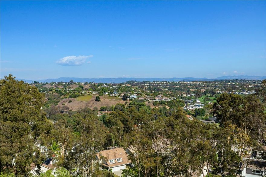 This exceptional 4-bedroom residence, in the highly sought-after hillside enclave of Niguel Summit, is perfectly situated on a private, single-loaded street with panoramic views that stretch from Saddleback Mountain to the Pacific Ocean. Inside, natural light fills the open layout, enhanced by soaring cathedral ceilings, fresh interior paint, and newly installed recessed lighting throughout. The home showcases the largest floor plan in the Paragon tract, and is designed for comfortable everyday living and effortless entertaining. The main level offers a coveted downstairs bedroom and a full bathroom—ideal for guests or multi-generational living—along with new flooring that flows throughout the space. Upstairs, a versatile bonus room can easily serve as a fifth bedroom, office, media room, or play area. A distinctive bridge walkway connects the primary suite to the secondary bedrooms upstairs, and blends privacy and architectural sophistication. The primary suite is a true retreat, featuring expansive windows that frame the panoramic vistas, while the remodeled bathroom boasts a walk-in shower, oversized soaking tub, generous walk-in closet, and spa-like finishes. Notable upgrades include a fully paid solar system for energy efficiency and long-term savings.This prime location is minutes from world-class destinations including Monarch Beach and Ritz-Carlton resorts, the El Niguel Country Club, and top-rated schools. Explore the charm of Laguna Beach, the revitalized Dana Point Harbor, and pristine coastal beaches—all within easy reach. Blending privacy, luxury, and panoramic views, this Niguel Summit home offers the quintessential Southern California lifestyle.