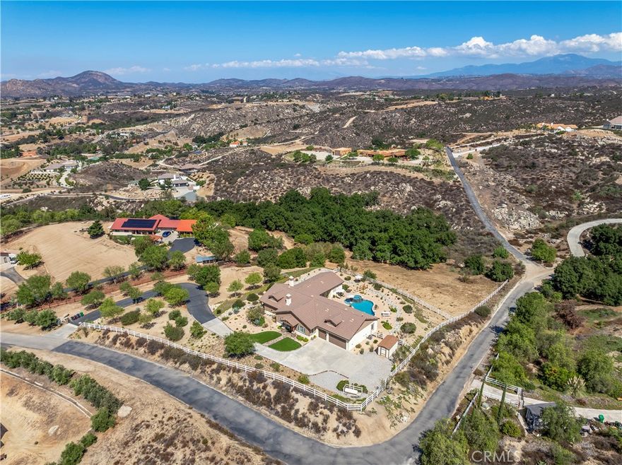 Welcome to your private Wine Country retreat! Nestled on nearly 5 acres of usable land, this single-story estate captures unparalleled 360-degree views of Temecula’s rolling vineyards and stunning sunsets. Designed for both comfort and entertaining, this residence offers 4 bedrooms, 4.5 bathrooms, plus a dedicated office and private automatic gated entrance—the perfect blend of elegance and functionality.



Inside, you’ll find a thoughtful floor plan that balances style and space. The home features a formal living and dining room with a cozy fireplace, perfect for intimate gatherings or holiday celebrations. The expansive great room seamlessly opens to the chef’s kitchen, creating the ultimate space for entertaining. The kitchen boasts stainless steel appliances, granite countertops, and ample cabinetry—a dream for any culinary enthusiast. Additional upgrades include surround sound speakers throughout the house and backyard, a whole-house fan, and a water softener, enhancing comfort and convenience.



The primary & one additional secondary bedroom has its own full ensuite bathroom, bedrooms three & four both have a shared ensuite bathroom ensuring privacy for family and guests, while the office provides a quiet, versatile space for remote work or creative pursuits. There is also a fourth full bathroom in the hallway as well as additional half bath by the Great Room. 



Step outside to embrace the true California lifestyle. Enjoy the sparkling pool and spa, or relax on expansive patios surrounded by professional drought-resistant landscaping. At the bottom of the property, a seasonal creek meanders through a natural oak grove, adding serenity and character to the landscape. With nearly 5 acres of mostly usable land and the potential for dual access, the possibilities are endless—plant your own vineyard, design equestrian facilities, or simply soak in the wide-open space.



Recent updates, including a new HVAC system, tankless water heater, and stylish wood laminate flooring, provide modern efficiency and peace of mind. A spacious 3-car garage adds convenience and functionality.



All this, just minutes from Temecula’s world-class wineries, dining, and shopping, yet offering unmatched serenity. This is Wine Country living at its finest.