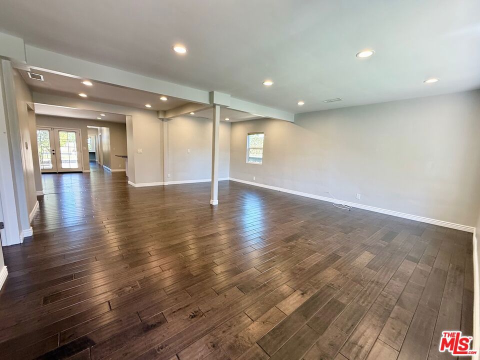 This beautifully updated 3-bedroom, 2-bathroom home offers the ideal layout for comfortable family living. Enjoy a spacious living room, separate dining area, and rich dark hardwood floors throughout. The primary suite features a private bath with double sinks and marble countertops, while the second bathroom includes a double vanity with stylish vessel sinks. The kitchen is a chef's dream with granite countertops, a center island, and a striking tile backsplash. The property also includes a detached guest unit with its own full kitchen and bathroom perfect for your guests, the ultimate playroom/gym, or a private home office. Outside, enjoy a large backyard with a sparkling pool and patio area ideal for entertaining. Located south of Ventura Blvd and just a short walk to the vibrant Tarzana Safari Walk, with easy access to Trader Joe's, popular restaurants, boutiques, and salons.