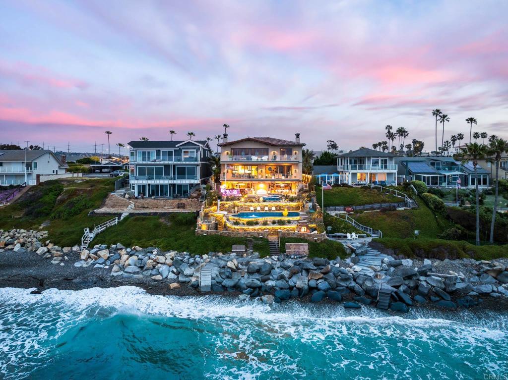 Experience unparalleled coastal luxury with this extraordinary beachfront estate, offering private beach access in the prestigious Tierra del Oro enclave of Carlsbad. Here, the rhythmic sound of white-water waves and vibrant sunsets over the Pacific are not just scenic moments—they're your everyday backdrop.Set on a rare, private 1/3-acre lot with 63 feet of direct ocean frontage, a pool overlooking the ocean (rare find and may not be able to be built again), this custom European-inspired masterpiece combines timeless craftsmanship with refined modern elegance. Meticulously updated throughout, the 6,480-square-foot residence offers up to 5 spacious bedrooms, 4 full bathrooms, and a stylish powder room, all thoughtfully arranged within a flowing open-concept design that seamlessly connects formal and informal living spaces.Every inch of this home has been curated with unmatched attention to detail—featuring rare, hand-selected stones and hardwoods, artisan-crafted finishes, and custom solid wood millwork. Designer lighting and fixtures elevate the ambiance, while a lighted custom staircase connects all three levels of the home, adding a dramatic architectural focal point.Retractable glass doors on every level blur the line between indoors and out, revealing panoramic ocean views stretching from La Jolla to Dana Point and inviting in the sea breeze. The result is a truly seamless indoor-outdoor living experience, ideal for both intimate relaxation and grand entertaining.Host with distinction with a stunning, glass-walled, temperature-controlled wine cellar paired with a sleek service bar, icemaker, and abundant storage—perfectly suited for gatherings and celebrations. Step outside to a breathtaking exterior oasis, complete with a lushly landscaped front courtyard entry, sparkling swimming pool(unique and may be hard to replicate), spa, and expansive summer kitchen with dining bar. Lounge by the fireplace or fire pit, sip cocktails as the sun sets, or dine alfresco under the stars, all while taking in uninterrupted views of the Pacific coastline. Additional exceptional features include: Steps leading to the private “wet sand beach”, Pool overlooking the ocean is a rare find and may not be able to be built again, Oversized 3-car garage, Office/library, Lutron lighting system, Five interior gas fireplaces, Outdoor heaters and shower, LED lighting throughout, Extensive exterior lighting, Copper gutters, downspouts, and trim, Custom storage for surfboards and water toys, Generous interior storage solutions. This exquisite estate is more than a home—it’s a lifestyle of unparalleled beauty, comfort, and coastal sophistication. Experience the very best of Carlsbad luxury living.