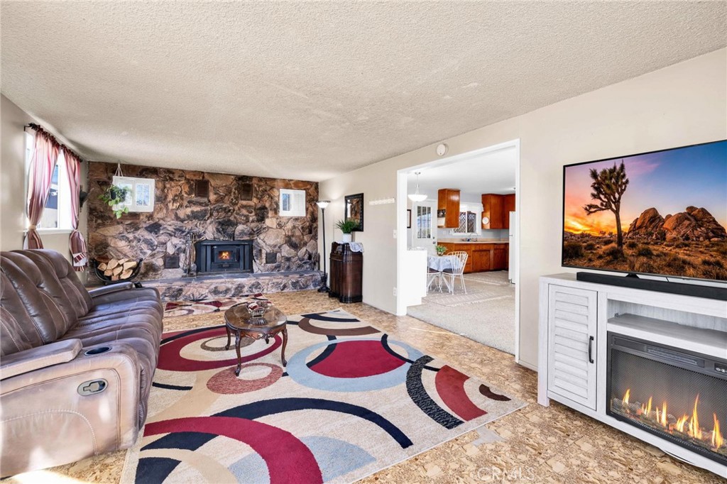 Charming and well kept home at an amazing price! Located in the scenic Hidden Rivers area of Joshua Tree. This is the one you've been waiting for! wonderful, 2 bedroom 1 bath home that offers comfort, space and stunning Desert views! Enjoy the inviting family room that features a beautiful stone fireplace with a wood burning insert for those cozy, chilly desert nights. You'll love all the large windows that fill the home with natural light. The adorable kitchen has plenty of cabinets and ample counter space. Step outside to the huge yard that is fenced all around both front and back; complete with an inviting covered patio, picnic area, and an above ground pool, great for relaxing and entertaining. The 572 sq. ft detached garage provides plenty of room for parking, storage or a workshop with tons of outdoor space for an RV, boat, ATV's or even to build an ADU. This home is conveniently located near the Elementary School and just minutes form Joshua Tree National Park, local restaurants, shops and the Farmers Market. a Fantastic opportunity for first time home buyers or as an investment property. Schedule your showing today!