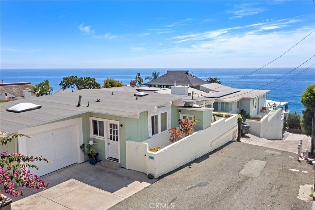 Charming ocean view beach cottage located just steps away from Table Rock Beach. Ocean and Catalina Island views from both the main living spaces as well as the home's 30-foot long wraparound deck. Located on a private cul de sac street with the pleasant sounds of the ocean waves crashing onto the rocks below. Walk about 60' away, to a private locked beach access gate and stairs that lead directly to Table Rock Beach. This 3-bedroom, 2-bathroom remodeled home with real hardwood floors is move-in ready. The main rooms consist of a living room with gas fireplace, with a dining area, and open to the kitchen, which offers additional bar seating for two. Kitchen is fully equipped including dishwasher. With double French-doors leading to the view deck, the home seamlessly blends both indoor and outdoor living. The spacious primary bedroom features an en-suite bathroom with jetted tub and separate shower. The second bedroom is also spacious, and is light and bright. The third bedroom has a separate entrance and windows on two sides. Both guest bedrooms share a hall bathroom that features a walk-in shower. This property has an attached 1-car garage with two remotes and driveway parking for 2 additional vehicles. Plus, public parking is available just up the street with 9 parking spaces providing 3-hours of free parking during the day. This is your chance to live the quintessential Laguna Beach lifestyle.