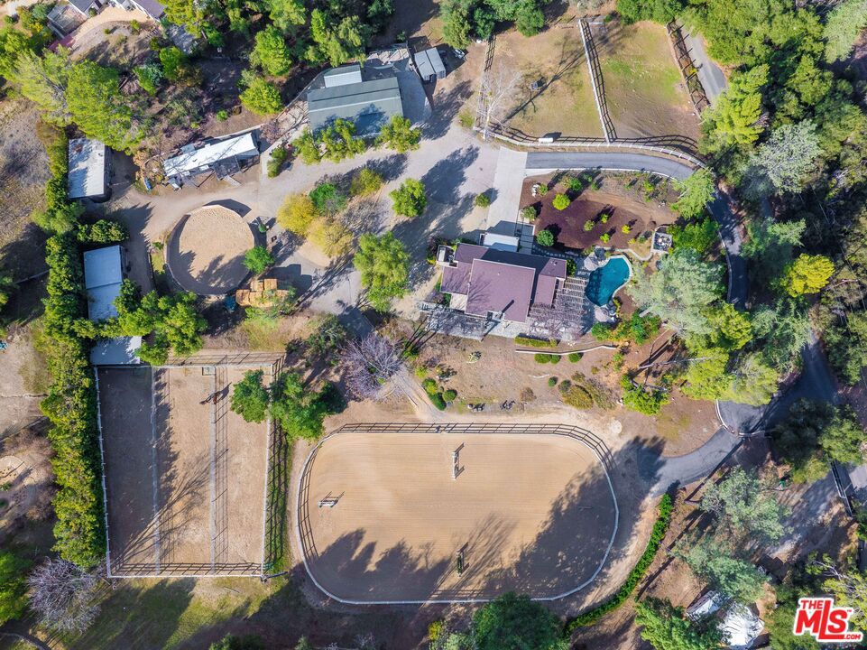 Welcome to Cold Creek Ranch, a world class equestrian estate, nestled in the Malibu/Calabasas Mulholland corridor of the Santa Monica mountains and tucked away behind gates on a private country road. The property spans two legal lots and more than 5 picturesque usable acres. The residence itself is an idyllic ranch escape, thoughtfully designed to blend luxury with its natural surroundings. Featuring an open floor plan, the great room showcases vaulted, beamed ceilings and clerestory windows, providing natural light and creating an ambiance of timeless sophistication. The one-story oasis features three bedrooms, two bathrooms and a glass enclosed office. The chef's kitchen offers a center island, teak cabinetry, imported stone countertops, a breakfast bar and a butler's pantry. The primary suite, situated in its own private wing, offers direct access to a serene retreat with a pool and spa. The spa-like bathroom is a sanctuary of relaxation, complete with a spa tub, steam shower, and dual walk-in closets. The estate's expansive, wisteria-draped verandas provide the perfect setting to unwind while enjoying breathtaking views of the jumping ring and horses in their turnouts. This three bedroom, two bathroom home captures the essence of elegance and comfort, complementing the property's natural beauty. Equestrian facilities are designed to satisfy the needs of the most discerning enthusiast. The property boasts a 10-stall breezeway barn equipped with excellent drainage, pavers throughout high-traffic areas, and a custom tack room. 7 paddock stalls, 5 expansive turnouts, a round pen, and a standard-size jumping arena measuring 100x195 offer exceptional functionality for training and riding. A hot-cold shower bay for horses ensures convenience and care for equine companions. The enchanting setting of this estate is equally captivating. A private, gated driveway winds gracefully through a canopy of majestic oak trees, leading to your equestrian oasis, where panoramic views of the stunning Santa Monica Mountains unfold. The natural landscape creates an atmosphere of serenity and seclusion that is truly magical. For added convenience, the property includes quarters for a groundskeeper. With direct access to miles of hiking and horseback riding trails within the Santa Monica Mountains National Recreation Area, this estate offers an outdoor lifestyle that is second to none. From its recently upgraded horse facilities to its magical setting and luxurious amenities, this estate represents a rare and extraordinary opportunity to own a piece of equestrian paradise. The property included APN'S 4455-020-018 and 4455-020-045.
