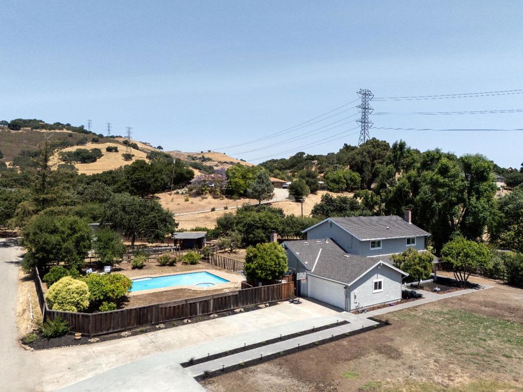 Do not miss this rare blend of privacy, elegance, and convenience with tranquil country living just minutes from the heart of Silicon Valley! This beautifully remodeled 4BD/3BA home offers 2,649 sq ft of stylish country living on nearly an acre of land. A true entertainer's dream, the chef's kitchen features a large island, peninsula, premium appliances, wine/beverage cooler, pantry, and storage. The bright, open layout includes two wood-burning fireplaces, wide-plank French oak floors, Emtek crystal doorknobs, and Swarovski crystal stair spindles. The spacious primary suite includes a walk-in closet, spa-like bath with oversized shower, soaking tub for two, and skylights. One bedroom on the main level. Dual-zone heating + whole-house fan ensure year-round comfort. Outdoors, enjoy a sparkling pool/spa, paver patio & walkways, fruit orchard, raised garden beds, space for expansion or livestock. The large insulated 508 sq ft outbuilding offers endless possibilities, e.g., ADU, workshop, studio, gym, storage, etc. Zoned for horses/livestock, with ample RV/boat parking. Newer 50-year roof, irrigation well + city water, and room for your dream outdoor kitchen or sport court. Top-rated schools, minutes to various hiking trails, biking, Calero Reservoir, golf courses, and vineyards.