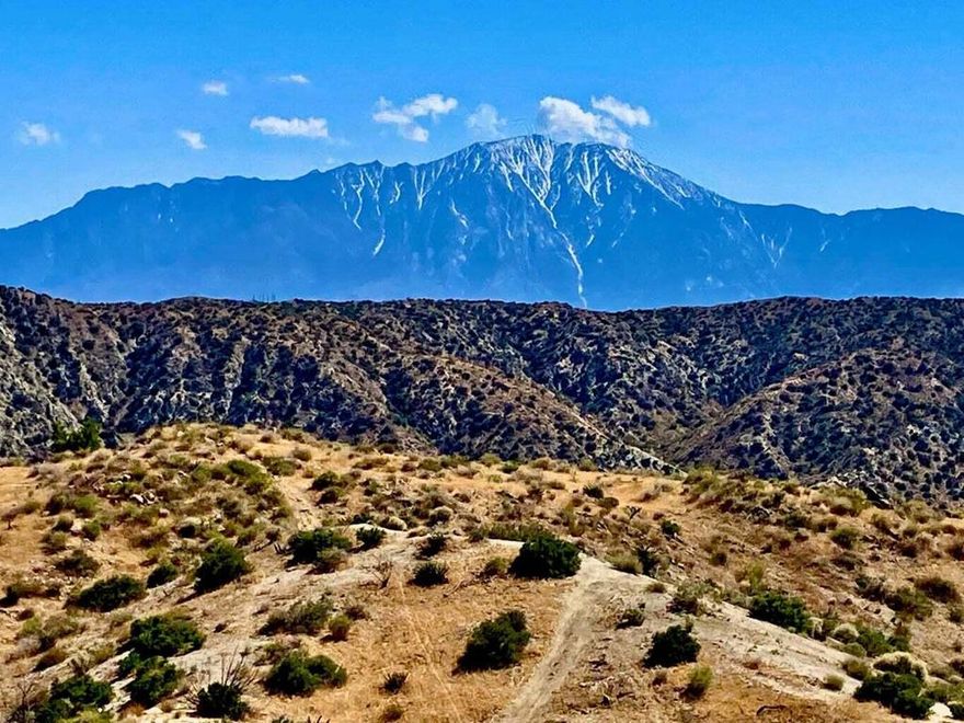 A panoramic hilltop lot that feels like you/re on an 'Island in the Sky'! 5 acres with 360' views. High up on a large graded pad. Truly amazing views of Mt San Jacinto and Mt San Gorgonio. The awe and inspiration cannot be matched. Permitted well with city water, power, and paved street about 330'. The driveway leads to a spacious graded pad that is so large it may offer space for house, pool, guest house and plenty of parking. More building area down the slope. A separate driveway leads to the lower level with a small graded pad for a second home. Rare opportunity to create a breathtaking showpiece architectural compound. Million dollar homes in the area. Property borders thousands of acres of government wilderness land for hiking and horseback riding. Morongo Valley is becoming known for it's multi million dollar hideaways. Short drive to Palms Springs. 22 miles to Joshua Tree National Monument. About 3 million tourists visit the park annually. 41 miles to Coachella. 112 miles to Los Angeles. Very hot vacation area. Buyers must contact the county for all questions on building and uses. Buyers must contact the utilities agencies for all questions on utilities. APN: 0584-111-02 Address is not a real address, & is for marketing purposes only. GPS: 34.043200, -116.595983