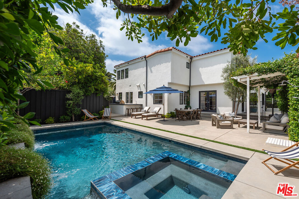 Gated turnkey home tucked away on a secluded flag lot in the heart of Sherman Oaks' coveted Chandler Estates, this stunning 4-bed, 4.5-bath estate blends timeless 1920's Spanish character with modern luxury and resort-style living. Meticulously remodeled and exquisitely landscaped, this gated private compound offers the ultimate California indoor-outdoor lifestyle. Inside, the home features a sunlit, spacious layout with a dining room perfect for entertaining. Adjacent, a formal living room centered around a wood-burning fireplace opens out to a cozy fire pit lounge framed by a 100-year-old Japanese maple tree, mature olive trees, lush turf, and a private putting green. The chef's kitchen boasts polished Carrara marble countertops, top-of-the-line Thermador appliances, and a spacious breakfast bar for four. It seamlessly transitions into a welcoming family room with double doors that lead to the pool. Upstairs, the primary suite offers an expansive layout, featuring a spa-like bathroom with dual vanities, a soaking tub, a private water closet, and a generously sized walk-in closet. Two additional upstairs bedrooms feature en-suite baths and custom closets. A fourth bedroom, located downstairs, also has its own en-suite bathroom, providing flexibility for a guest room, a home office, or private quarters. An additional bright office space overlooking the backyard makes working from home a dream. Step outside and immerse yourself in the newly built pool, featuring cascading waterfalls, a relaxing jacuzzi, and an outdoor shower. Indulge in culinary delights in the Tuscan-inspired dining area, complete with an outdoor kitchen. The rental includes Restoration Hardware teak outdoor furniture, providing ample space to entertain and relax with friends and family. Additional highlights: gated flag lot with full privacy, 220V fast-charge electric car charger (50kW), newly-epoxied garage with storage racks and an extra fridge, long gated driveway ideal for kids' play or additional parking, professionally landscaped grounds with new turf and your own private hitting bay for the golf lover. Easy commutes to Lawrence, Harvard Westlake, Campbell Hall & Buckley. Secluded and a rare sanctuary in the city, this gated Sherman Oaks home offers the perfect blend of character & luxury. Available now for lease.