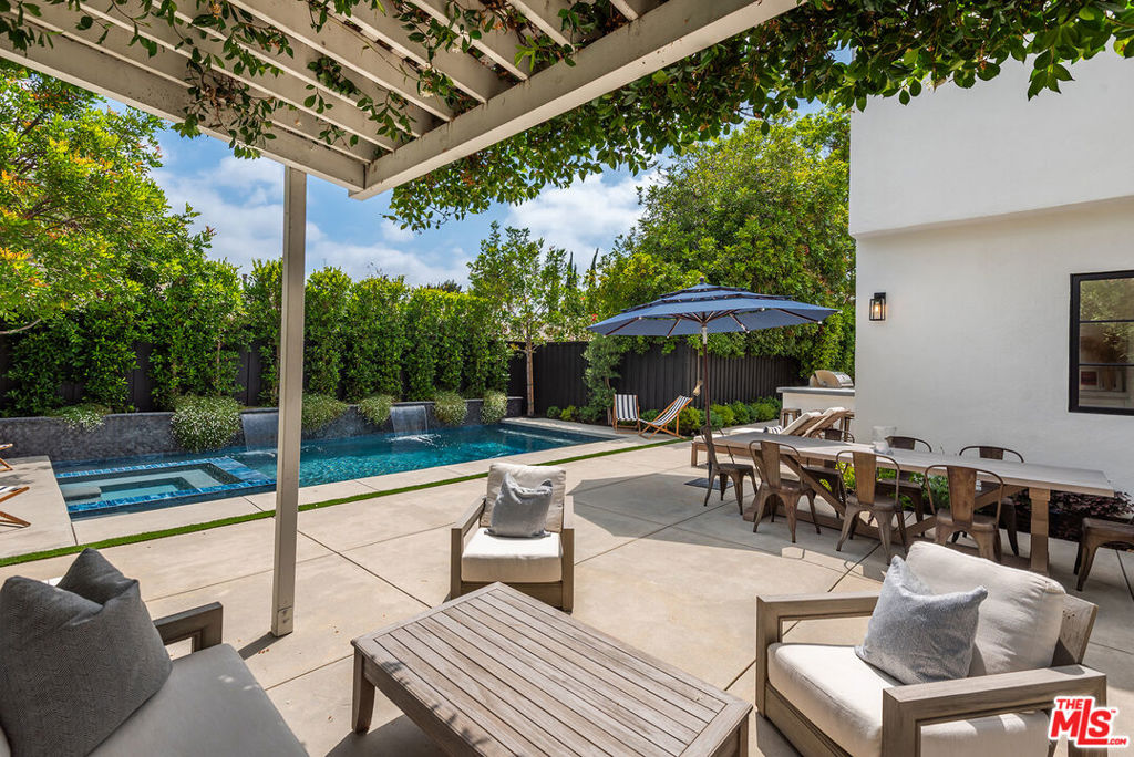 Stunning gated estate property tucked far behind gates on a secluded flag lot in the heart of Sherman Oaks, this stunning 4-bed, 4.5-bath home blends timeless 1920's character with modern luxury and resort-style living. Meticulously remodeled and exquisitely landscaped, this amazing private compound offers the ultimate California indoor-outdoor lifestyle. Inside, the home features a sunlit, spacious layout with a dining room perfect for entertaining. Adjacent, a formal living room centered around a wood-burning fireplace opens out to a cozy fire pit lounge framed by a 100-year-old Japanese maple tree, mature olive trees, lush turf, and a private putting green. The chef's kitchen boasts polished Carrara marble countertops, top-of-the-line Thermador appliances, and a spacious breakfast bar for four. It seamlessly transitions into a welcoming family room with double doors that lead to the pool. Upstairs, the primary suite offers an expansive layout, featuring a spa-like bathroom with dual vanities, a soaking tub, a private water closet, and a generously sized walk-in closet. Two additional upstairs bedrooms feature en-suite baths and custom closets. A fourth bedroom, located downstairs, also has its own en-suite bathroom, providing flexibility for a guest room, a home office, or private quarters. An additional bright office space overlooking the backyard makes working from home a dream. Step outside and immerse yourself in the newly built pool, featuring cascading waterfalls, a relaxing jacuzzi, and an outdoor shower. Indulge in culinary delights in the Tuscan-inspired dining area, complete with an outdoor kitchen. The rental includes Restoration Hardware teak outdoor furniture, providing ample space to entertain and relax with friends and family. Additional highlights: gated flag lot with full privacy, 220V fast-charge electric car charger (50kW), newly-epoxied garage with storage racks and an extra fridge, long gated driveway ideal for kids' play or additional parking, professionally landscaped grounds with new turf and your own private hitting bay for the golf lover. Easy commutes to Lawrence, Harvard Westlake, Campbell Hall & Buckley. Secluded and a rare sanctuary in the city, this gated Sherman Oaks home offers the perfect blend of character & luxury.