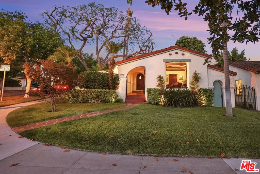 Set behind a classic arched courtyard filled with bougainvillea and the sound of a bubbling fountain, this 1931 Spanish Colonial Revival draws you into something special. Situated in the heart of Glendale's Rossmoyne Historic District, a neighborhood known for some of the city's most beautiful Spanish architecture, the home balances historic character with thoughtful updates that respect its past. The carved wooden front door opens to a welcoming entry where soft arches and a magnesite floor create an elegant first impression. From here, step down into the living room with its original French windows, vaulted beamed ceiling accented with hand-stenciled details, and a fireplace surrounded by handmade tiles from the historic Markoff Mosaic Tile Corporation. Peg-and-groove hardwood floors carry through much of the home, bringing warmth and texture to each space. Across from the living room, the dining room looks onto the courtyard fountain and offers generous proportions, setting the stage for gatherings. The updated kitchen is bright and functional, blending seamlessly with the home's style and offering plenty of room for cooking and connection. One and 3/4 bathrooms reflect the home's 1931 roots with restored tilework, while three bedrooms provide comfortable retreats, including an en-suite that opens to the veranda and backyard. Outdoors, a flagstone-paved yard surrounds the expansive spa beneath twinkling lights and umbrellas, framed by stucco walls and mature greenery. The shaded veranda just off the house offers a relaxed spot to lounge or entertain, making the backyard feel like a private retreat. Additional updates include copper plumbing, newer central air and heat, and a bolted foundation. 1148 Cordova is a home where history feels alive and daily life fits right in.
