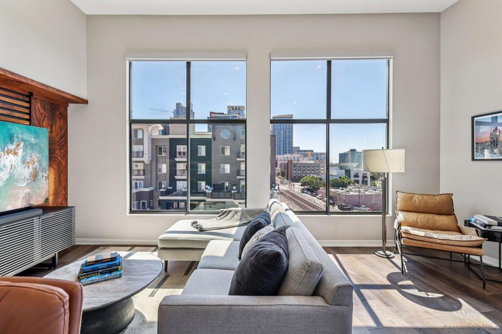 Experience breathtaking city and bay views from the top-floor, corner penthouse in DOMA—right in the heart of Little Italy. Rarely available and single-level, this 2 bedroom / 2.5 bathroom, 1,375 SF residence pairs dramatic high ceilings and an open, airy floor plan with wall-to-wall urban energy and sparkling water vistas from the living room and both bedrooms. A spacious private balcony —perfect for grilling and sunset watching— extends your living space outdoors. Two reserved, side-by-side parking spaces are conveniently located near the elevator for effortless city living. Inside, thoughtful upgrades elevate everyday life: luxury vinyl plank floors, new carpet, fresh paint, and a reimagined chef’s kitchen with quartz counters, new cabinetry, sink, and backsplash, plus a suite of newer smart appliances (cooktop and fridge). The living area features custom wood paneling by a local artist, while electric smart shades in the living room and bedroom dial in light and privacy with a tap. Both bathrooms showcase new tiling; the primary suite shines with a fully redone bath (new shower, dual sinks, lighting, cabinetry, and quartz backdrop) and a custom built-in closet. Ample cabinetry maximizes storage throughout and a spacious in-unit laundry room adds everyday convenience. Step outside your door to Little Italy’s restaurants, cafés, and weekend mercato—or head upstairs to DOMA’s rooftop deck for sunsets and the fitness room for on-site wellness. This is the one you’ve been waiting for!