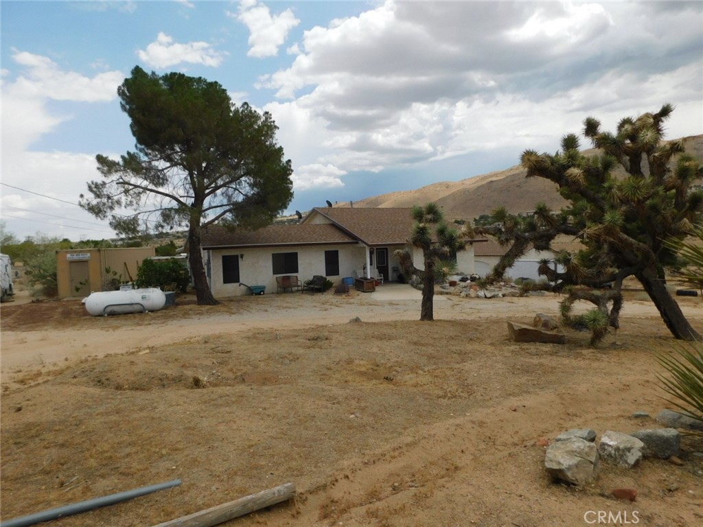 Here is a great starter home with plenty of room to add on and grow. Assessors says 1 bedroom 1 bath, however there is another area off the back that being used as a 2 bedroom. Older aged home that has had some updating. Kitchen has had a remodel with a farm sink small island, windows have already been changed out. Wood burning stove in the main bedroom. Large main bath with jacuzzi tub. Half bath off the living room. Nice large living room. Laundry closet in the kitchen. Nice dining area. Ceiling fans in the living room, dining area and the main bedroom. Tile floors throughout. Newer roof, Central heat and air. Nice usable 5 acres. Detached 3-car garage. 1 large container with electric, 1 medium sized container. Both stay with the property. Large shed and vegetable greenhouse. This home has a lot to offer someone who wants to live in the country and close to the city.