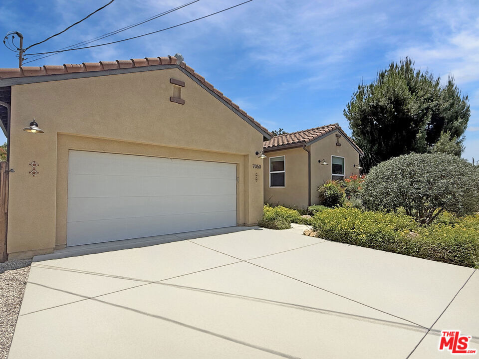 Welcome to this beautifully crafted modern Spanish-style residence, built in 2013 and thoughtfully enhanced with designer upgrades that elevate both form and function. Featuring 4 bedrooms and 2.5 bathrooms across 1,683 square feet, this home offers a seamless blend of style, comfort, and smart living. Step inside to an open-concept floor plan accentuated by warm bamboo flooring, custom window treatments, and dual-pane windows that bathe the interiors in natural light. The gourmet kitchen is a chef's delight complete with updated cabinetry, granite countertops, stainless steel appliances, and abundant workspace for effortless entertaining or everyday cooking. The spacious primary suite serves as a private retreat, boasting a recently remodeled en-suite bathroom and a generous walk-in closet. Designed with modern convenience in mind, the home features high-speed network wiring in every room, fresh interior paint, and an upgraded Trane multi-zone HVAC system with WiFi control for personalized climate comfort. Enjoy true peace of mind with OWNED SOLAR PANELS (no lease or payments), a Generac whole-home generator, fire sprinkler system, and a comprehensive security camera system. The oversized two-car garage offers exceptional storage, while the professionally designed, drought-tolerant landscaping in the front and back yards delivers curb appeal with minimal upkeep. The backyard is a private oasisfully enclosed by lush hedges and ideal for entertaining, complete with a grassy lawn (with room for a pool), and a serene outdoor seating and dining area perfect for relaxing or hosting under the stars. Located within walking distance to Hart Elementary and minutes from shopping, dining, and places of worship, this home offers a rare opportunity to own a move-in-ready gem in one of Canoga Park's most sought-after neighborhoods.