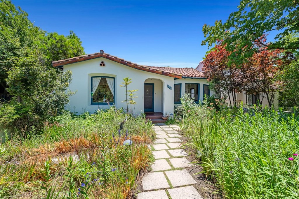 Located within the coveted Claremont Village, 456 W. Baughman Avenue is a 1929-built residence that beautifully blends period craftsmanship with thoughtful modern enhancements. Offering approximately 1,825 square feet of living space, this Spanish-style home showcases an award-winning Hartman Baldwin-designed carport, an architecturally sensitive feature that doubles as a versatile outdoor entertaining space. In front, an enchanting English garden draws butterflies and hummingbirds, adding to the home’s exceptional curb appeal and timeless charm. Inside, original oak flooring and vintage architectural details speak to the home’s rich history, while a Hartman Baldwin-designed chef’s kitchen provides the form and function today’s homeowners value. The flexible layout includes 3+ bedrooms and 1.75 bathrooms. A fourth bedroom, currently open for expanded use, can easily be enclosed. One pass-through bedroom offers a variety of potential configurations, including an expanded primary suite or private office retreat. At the rear of the property is a spacious bonus room outfitted with wine refrigerators suited for a serious collector. Warm, inviting, and reflective of an era where quality and character reigned, yet with tasteful updates throughout, this home offers a rare opportunity to own a piece of Claremont’s architectural legacy.