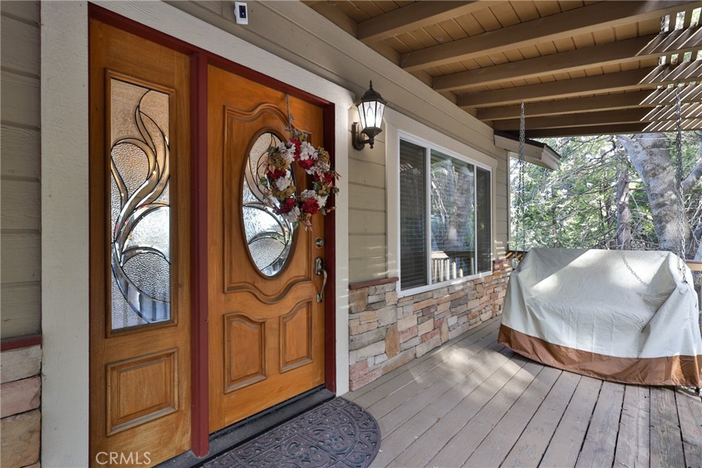 Spectacular Crestline home with Awe Inspiring Views of Lake Gregory and Mt Baldy. Enjoy this newer 3 bedroom 3 baths home with a level entry Garage and covered Front Porch complete with Bench Swing. The main level living, dinning area offers hardwood flooring, a stone fireplace, and open to the spacious Kitchen with granite countertops, dual ovens, and center island with copper vegetable sink. Absolutely Ideal for Entertaining! The bedrooms are downstairs off of the Game Room and second deck. The Master Bedroom with rock fireplace and large ensuite bath is your own sanctuary. All 3 Levels have Decks with Panoramic Views. Take in the Amazing Sunsets, Star Filed Sky's, and even the 4th of July Fireworks over the Lake. The 3rd level is accessed by exterior stairs and ready to be completed as an ADU or utilize the builder designed access to allow for an interior staircase to expand to be a full 3 level home. Additionally, the house is located at the end of the Road offering Extra Privacy! This is the one you've been waiting for!