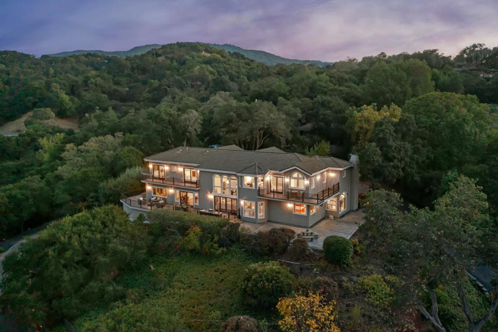 Indulge in breathtaking city lights and mountain panoramas from this exquisite Los Gatos estate, nestled within the confines of a secure gated property spanning 1.67 acres. Beyond the grand entrance, a 4,900+/- square-foot haven awaits, boasting 5 bedrooms and 4.5 baths that seamlessly blend opulence with a welcoming ambiance. Hardwood floors, expansive picture windows, lofty ceilings, and generously proportioned spaces define the tastefully adorned interior, creating an inviting atmosphere for both relaxation and entertainment. The residence effortlessly integrates indoor and outdoor living, with numerous rooms offering direct access to the outdoors. The meticulously landscaped grounds showcase illuminated gardens, mature foliage, stately trees, and multiple areas designed for entertaining. This haven provides a harmonious balance of seclusion and convenience, being in close proximity to the vibrant downtown Los Gatos, parks, hiking trails, schools, and major freeways. Noteworthy features include an elevator, a reliable generator, ensuring uninterrupted power, and a sophisticated alarm system, enhancing the security of this remarkable property. Experience the epitome of luxury living with breathtaking views, refined interiors, and modern amenities in this Los Gatos estate.
