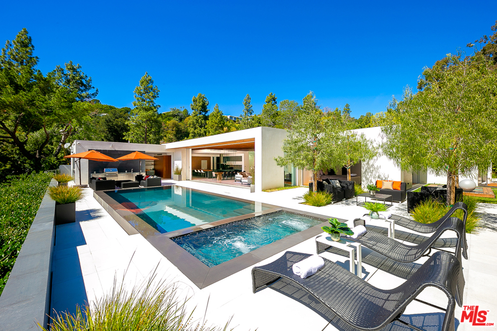 Located in one of the most coveted neighborhoods of Los Angeles, this property is a masterpiece of light and design. The gated motor court leads to an oversized pivot door which opens into a dramatically walled hallway gallery. This gorgeous single-story modern marvel features impeccable high-end finishes including an owners suite showcasing Snaidero closets, wellness spa, and a Yoga deck off the suite, Fleetwood vanishing walls of glass, grand-scale chefs Bulthaup kitchen with Gaggenau appliances, and a stunning 600-bottle wine wall, multi-zone interior/exterior sound system. The Kalamazoo outdoor kitchen perfectly complements a zero-edge pool/spa and the private grounds with their lavish views down into the City of Beverly Hills and beyond. This estate is a true embodiment of the Southern California indoor/outdoor lifestyle living. Conceived by Urban Architecture Lab, completed in 2018 with a GSF of 8,500.