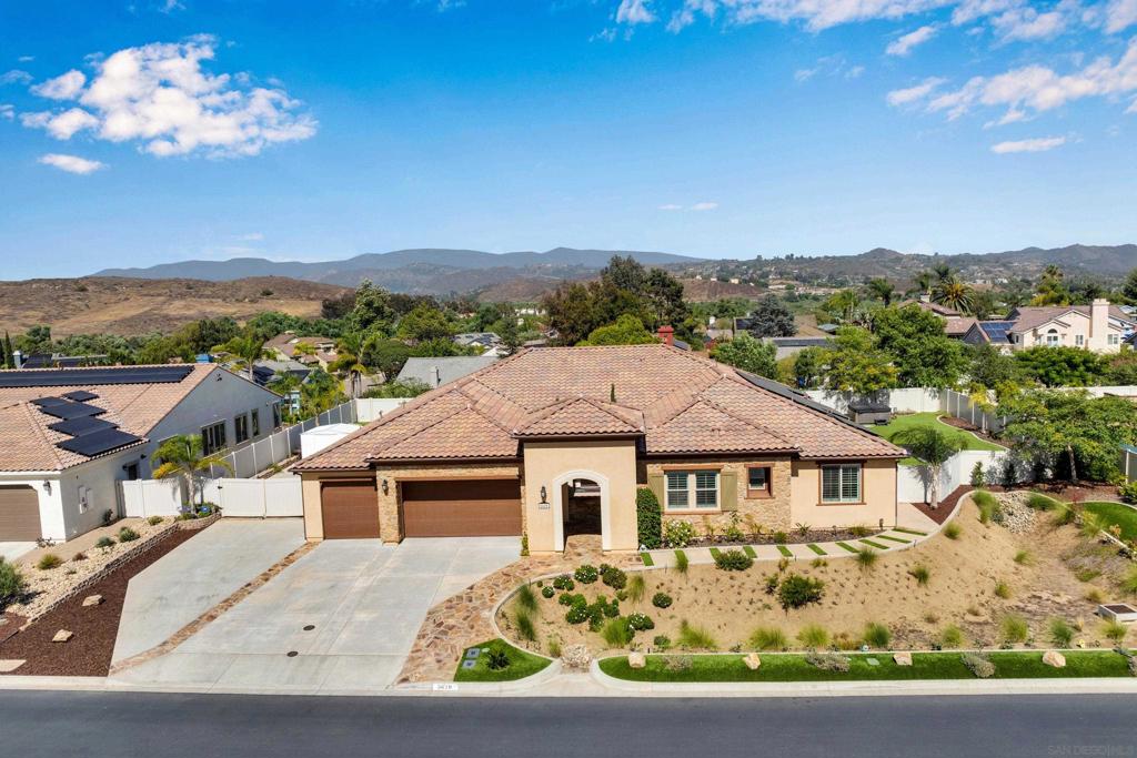 Welcome to this exquisite property nestled in the charming community of Bonsall, California. This impressive home offers a spacious 3,846 square feet of living space, featuring 5 bedrooms and 3.5 bathrooms. Step inside to discover a thoughtfully designed interior that effortlessly blends elegance with functionality. The formal living room invites you in with its fireplace, surround sound, and built in bookshelves, perfect for hosting intimate gatherings. Culinary enthusiasts will appreciate the gourmet kitchen, boasting two expansive islands, granite countertops, and upgraded stainless steel appliances, including dual dishwashers for added convenience. The family room/den is a versatile space complemented by a custom built-in desk, offering picturesque views of the backyard. The primary bedroom is a tranquil retreat, granting direct access to the outdoor area, while the primary bathroom pampers with dual sinks, a deep soaking tub, and a separate tiled shower. Venture outside to find an low maintenance, landscaped backyard oasis. The covered patio, complete with a ceiling fan, sets the stage for outdoor relaxation and entertaining. Additional features include artificial turf and an in-ground trampoline. There is a secret garden beyond the fence with roses; perfect for a chef garden. Situated on a generous lot at the end of a cul-de-sac, this property offers privacy with no neighbors in front. For added convenience, the home includes paid solar panels, air conditioning, and a three-car garage. Experience the tranquility and charm of Bonsall.