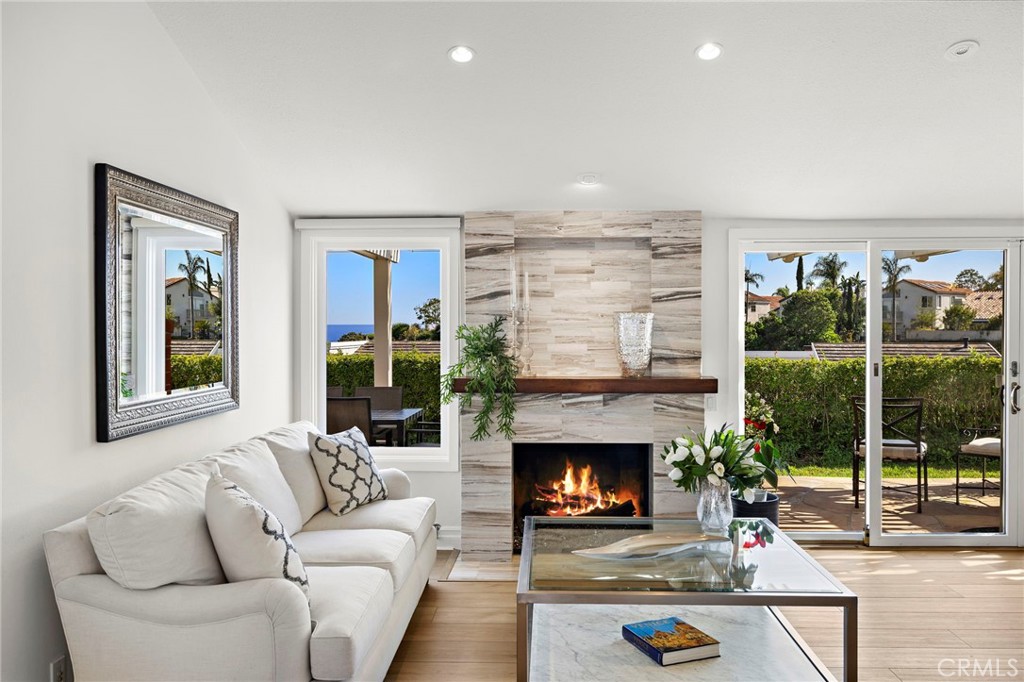 Welcome to Monarch Summit II, a highly sought-after 55+ community in the hills of Laguna Niguel. This single-story home offers hillside views from a serene, single-loaded street just one mile from the coast—close enough to enjoy the sea breeze, yet far enough to avoid beach traffic and noise. Beautifully updated, the home features an open kitchen and great room with peek-a-boo ocean views, Carrera marble counters, custom cabinetry, a beverage wet bar, and wine cooler. Enjoy modern comforts including new flooring, recessed LED lighting, marble fireplace, Andersen windows and doors, remodeled bathrooms, and an extended patio with flagstone flooring and a motorized courtyard awning for indoor-outdoor living. Energy efficiency abounds with 23 solar panels, 2 Tesla Powerwalls, an EV charger, a 2024 heat pump and A/C, central air purifier, Rinnai tankless water heater, and a newer roof. Monarch Summit II offers a peaceful, landscaped setting with active yet quiet neighbors—making this a rare opportunity to own a coastal retreat with resort-style living.