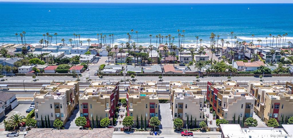 Panoramic Ocean Views and Modern Beach Vibe: A Rare Opportunity! Introducing this renovated 2005 townhome with breathtaking panoramic ocean views and a private roof deck. Recently updated and renovated, this home shows like a modern chic beach home. With an HOA fee of just $500/month covering all exterior maintenance and more, you can enjoy minimal responsibilities and the freedom to lock up and go. This property offers unparalleled value that is hard to find in today's market. Just 2 blocks to the beach and located in the gated Coastal Townlofts, this exclusive community of 28 units enjoys a prime location west of 101, offering not only panoramic ocean views but also stunning city views. This unit is unique as it is one of the only homes that have views of the ocean from the living area as well as the bedrooms (not just the private roof deck). This community was custom built with a special variance, so this townhome has soaring ceilings that are 10-11ft on every level. Situated just a few blocks from the beach, the pier, and downtown, and a stone’s throw away from the “quiet zone” Metro, this home provides unmatched convenience. The HOA enforces a minimum 30-day rental policy, ensuring a peaceful and serene living environment. Additionally, this beach community is primarily owner-occupied, which is a rare find. This end unit light and bright tri-level townhome offers a spacious and functional layout. The first floor features a 2-car garage, along with one bedroom with walk-in closet, en suite bath along with the main entry. (see sup) On the second floor, you'll find two primary bedrooms, each with ensuite bathrooms, spacious closets, and double vanities. There is even a dumbwaiter in the garage that transports groceries to the kitchen. The highlight of this home is the expansive 3rd-floor open kitchen, dining, and great room with a soaring 11-foot ceilings. However, your favorite spot for relaxation and entertainment will undoubtedly be the stunning top-story private rooftop deck, offering 360-degree unobstructed views. Reinforced by the builder, the deck is built for the 220v hot tub and stubbed for your natural gas BBQ and/or fire pit, eliminating the need for propane bottles. The updates include all new high-end stainless steel kitchen appliances, newer A/C condenser, newer tankless water heater, new luxury flooring throughout, new cabinetry, new quartz countertops and tile backsplash in kitchen and baths, updated facets and sinks, new light fixtures, and even a custom-coated garage floor. This home truly showcases the perfect blend of style, functionality, and quality craftsmanship. Say goodbye to fighting commuter traffic and enjoy the convenience of the nearby Oceanside train station, located just half a block away. Located in the quiet zone with access to the Coaster, the Sprinter, and Amtrak with extended routes to LA and San Diego, commuting has never been easier. Alternatively, you can explore the vibrant neighborhood on foot or bike, with countless restaurants, movies, shops, and weekly farmers markets and street fairs just moments away. This is your chance to own one of only 28 luxury coastal townhomes, and one of just seven similar end units. With its unbeatable location, stunning views, beautiful renovation, and unmatched value, this property is truly one-of-a-kind. Schedule your viewing today and seize this unique opportunity before it's gone.