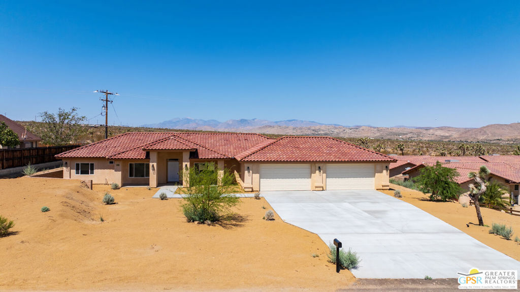 Modern Desert Luxury in the Heart of Joshua Tree! Discover the perfect blend of contemporary design and desert serenity in this new 4-bedroom, 3-bath home spanning 2,566 sq ft. Set on nearly half an acre with breathtaking mountain views, this single-story residence offers an open-concept floor plan ideal for both relaxed living and stylish entertaining. Inside, the chef's kitchen shines with granite countertops, walk-in pantry, and seamless flow to the spacious great room with a statement fireplace. Two luxurious primary suites one with dual showers and a walk-in closet create versatile living options for multi-generational families or guests. Sustainable and thoughtfully designed, the home features a solar system and energy-efficient finishes. The oversized 4-car finished garage, covered patio, and low-maintenance landscaping with timed irrigation make this a true turnkey retreat. Located minutes from Joshua Tree National Park, vibrant local shops, and dining, this property delivers the best of desert living modern comfort, spectacular scenery, and unmatched tranquility. Offered at $850,000 Your desert dream starts here.
