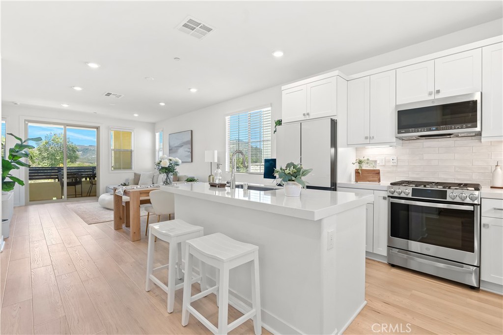 Imagine waking up to sweeping hill views all for under a million dollars. Welcome to your new home in Rienda, nestled within the award-winning Rancho Mission Viejo community. Just a short stroll from Boulder Pond and the brand-new playground, this bright end-unit feels like a private retreat year-round. Inside, discover three bedrooms each paired with its own full bath and a versatile main-floor suite that’s perfect for guests or a home office. From the living room and adjoining balcony, soak in panoramic vistas of rolling hills and California skies. Designed for today’s lifestyle, this home comes loaded with top-tier upgrades: paid-off solar panels, EV-charger pre-wiring and epoxy-coated garage floors, Ring alarm security, under-cabinet lighting, and premium kitchen backsplash and countertops. Every room is pre-wired for a ceiling fan or chandelier; plantation-style blinds and blackout curtains ensure total comfort. Luxe touches like upgraded hardwood flooring, high-performance carpet, and a spacious patio complete the picture. Under a million dollars and overflowing with features, this Rancho Mission Viejo gem won’t last long. Don’t miss your chance to live the Rienda life! Immerse yourself in the exceptional amenities of Rancho Mission Viejo, including the vibrant Ranch Camp, the state-of-the-art Ranch Cove community pool and gym, and countless recreational opportunities that define the unmatched lifestyle of this community. Exclusive to Rancho Mission Viejo residents are all amenities in the Villages of Sendero, Esencia, Rienda, and future Villages. There are community amenities for all from breath-taking resort-style pools and spas, Esencia school K-8, community farms, fitness centers, guest house, putting green, bocce ball courts, tennis and pickle ball courts, playgrounds, coffee shop, fire pits, an arcade and so much more!