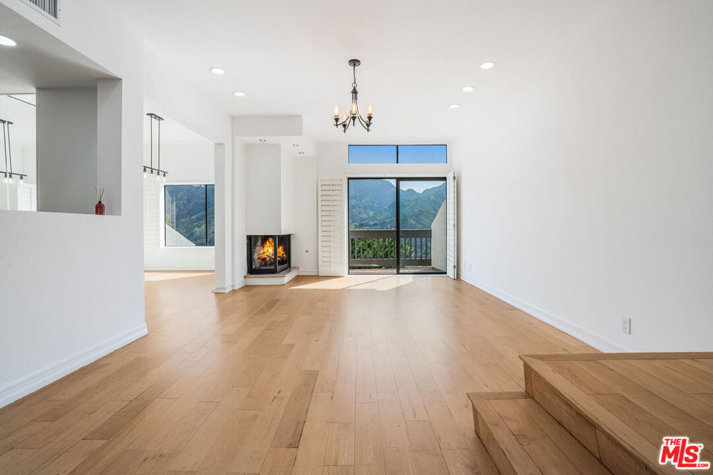 Discover the ultimate townhome experience in this exceptional 3-bedroom plus bonus room, 4-bathroom, 2,435 square foot residence with private direct access to a 2-car garage in the coveted Michael Lane Villas, nestled in the tranquil Palisades Highlands. This is your opportunity to own the crown jewel positioned on the LAST ROW with absolutely no neighbors behind you, offering commanding unobstructed views from your private sanctuary perched majestically at the top of all townhomes. Incredible value in the Highlands at just $677 per square foot, this west-facing gem features expansive windows that bathe the space in golden California light while showcasing stunning, unobstructed mountain vistas, plus breathtaking Pacific Ocean views from the primary suite's private balcony. What sets this property apart is its effortless accessibility with a straight shot drive directly to your private garage - no winding roads or complicated turns after leaving the main road, making daily life and guest directions infinitely easier. Guest entertaining is a dream with abundant parking right at your doorstep plus unlimited street parking on the main road with virtually no restrictions. Inside, the entry level offers a versatile living area perfect for an ensuite guest room, private gym, home theater, or game room, while the mid-level showcases a completely remodeled gourmet kitchen with brand-new appliances, custom cabinetry, and expansive countertops flowing seamlessly into an elegant dining area overlooking stunning landscapes and a bright family room with fireplace and balcony. The upper level primary suite sanctuary impresses with soaring cathedral ceilings, romantic fireplace, spacious walk-in closet, and that private balcony with sweeping ocean and mountain views that can never be obstructed. Recent luxury upgrades include fresh designer paint, brand new HVAC system, updated doors throughout, modern bathroom vanities, and energy-efficient LED lighting, while residents enjoy resort-style community amenities including sparkling pool, spa, and fully equipped fitness center. Offering strong investment potential with a proven rental income of $7,500 per monthand currently available for lease at the same ratethis front-facing near-end unit blends luxury living with financial savvy in one of LA's most desirable neighborhoods