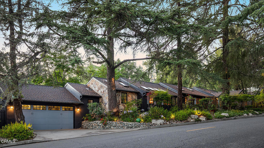 A Private Designer's Retreat with Fire Safety Innovations! Tucked behind a balinese gated entry and enveloped by majestic deodar trees, this sprawling 4 bedroom, 3.5 bathroom estate is an inspiring private oasis. With a lineage of interior designers as past and present owners, the home is an intentional masterpiece--where every room and outdoor space is a curated blend of style, comfort, and creativity. Colorful design moments fill the home with life, while abundant skylights and solar tubes bring in soft, natural light, adding dimension and warmth to every space. And beyond beauty, there's peace of mind: the current owner has installed a rare and thoughtful permanent copper rooftop sprinkler system powered by gas. It operates on house water during high-risk periods and automatically switches to draw from the pool in case of evacuation, offering enhanced fire preparedness. This home offers a convenient floor plan with an indoor-outdoor flow of common rooms in the center and two bedrooms on either wing. The bright eat-in kitchen offers high-end appliances with new Sub-Zero refrigerator, dishwasher, and wine fridge. A generous sized dining room with mirrored textured and paper covered walls, chandelier, skylights and French doors to the backyard. The custom designed living room features a fireplace, tin ceiling, reclaimed wood built-ins and collapsible doors to the outdoors. Designed for both solitude and inspiration, the property features tranquil outdoor living areas and a sparkling pool, making it ideal as an artist's retreat or entertainer's delight. Beyond the expansive patio lies a backyard designed for exploration - meandering paths, mature trees and natural landscaping perfect for imaginary play, tree climbing, and peaceful adventure. It's a rare setting that invites both children and adults to connect with nature. A two car attached garage with an abundance of attic storage and parking as the property is 180 feet wide. Additional upgrades include new windows, HVAC, new laundry, repiped copper plumbing, electrical updates, tankless water heater, new irrigation, whole house soft water system, security cameras, pool equipment, remodeled bathrooms and much more. Whether you're seeking serene privacy, safety or award winning La Canada schools, this one-of-a-kind retreat delivers on all fronts!