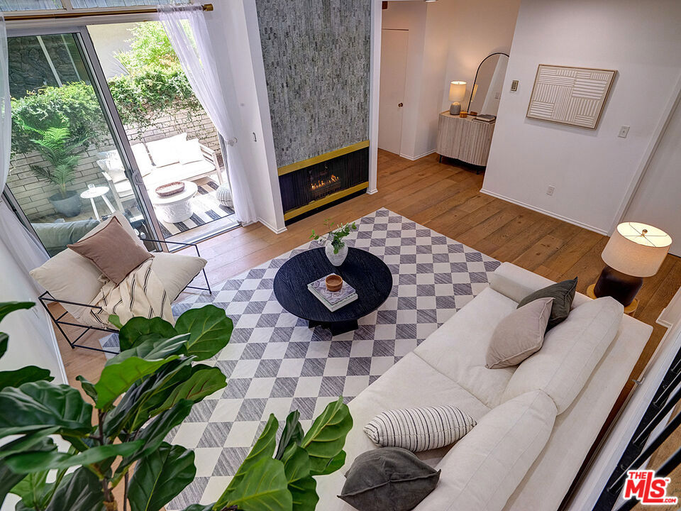Discover modern coastal living at its finest in this exquisitely designed 3-bedroom, 2.5-bath townhome that masterfully blends contemporary sophistication with tranquil outdoor living. Tucked away in Marina del Rey, this architectural gem offers an unparalleled lifestyle where sleek interior design meets lush private outdoor spaces. Step inside to discover soaring ceilings and an open-concept layout that creates a bright, airy atmosphere throughout. The thoughtfully designed interior showcases warm hardwood floors, crisp white walls, and an effortless flow between indoor and outdoor living. Large windows flood the space with California sunshine, creating a light and cheerful environment that invites you to relax and unwind. The heart of this home features a stunning gourmet kitchen with sleek gray Shaker cabinetry, pristine white marble countertops, and premium stainless steel appliances including a professional-grade Wolf range. The spacious waterfall-edge island provides ample seating and entertaining space, while the elevated dining area creates an intimate atmosphere for memorable gatherings with friends and family. A classic farmhouse sink and elegant backsplash complete this culinary masterpiece. What truly sets this townhome apart is its magical outdoor living space. Step through expansive sliding glass doors onto your own private patio oasis, where mature landscaping creates a living wall of greenery for ultimate privacy. Thoughtfully designed with contemporary lighting, this space feels like your own secret garden in the heart of the city. The charming front entrance, adorned with ivy-covered walls and elegant stonework, offers a preview of the botanical beauty that awaits within. Ascend to the private upper level where three bedrooms await, each designed as a peaceful retreat. The primary suite is a true sanctuary with sophisticated neutral tones and abundant natural light creating a bright, serene atmosphere. The primary includes a versatile bonus space with plantation shutters that could serve as a private dressing area, meditation space, or be customized with additional built-in closets. The spa-like primary bathroom showcases a gorgeous white dual vanity, classic subway tile with a striking geometric floor pattern, and a spacious glass-enclosed shower. Every detail exudes resort-level luxury. Additional bedrooms include a versatile guest room with abundant natural light, plus a hallway bathroom featuring eye-catching blue scalloped tile. The flexible layout ensures adaptability for growing families or remote work needs. Luxury finishes abound, including a sophisticated powder room with Restoration Hardware vanity. The thoughtful layout includes convenient laundry and ample storage solutions throughout, maintaining the home's clean, uncluttered aesthetic. Attached two-car garage provides secure parking and includes an expansive bonus storage area, offering the convenience and functionality of single-family home living in a townhome setting. Located moments from Marina del Rey's finest dining destinations including Pizzana, KazuNori, UOVO, and Sugarfish, plus convenient shopping at Trader Joe's and Ralphs. The HOA amenities elevate your lifestyle with a sparkling resort-style pool surrounded by mature landscaping and palm trees, creating a true California oasis. Additional community features include a covered outdoor dining pavilion with pergola and lush gardens, sauna, and beautifully maintained common areas with flowering trees and manicured grounds. This isn't just a townhome it's a sophisticated urban retreat that offers the perfect escape from city life while keeping you connected to everything Marina del Rey has to offer. A rare opportunity to own a piece of coastal paradise with luxury finishes, thoughtful design, and an enviable lifestyle. Come and be inspired!