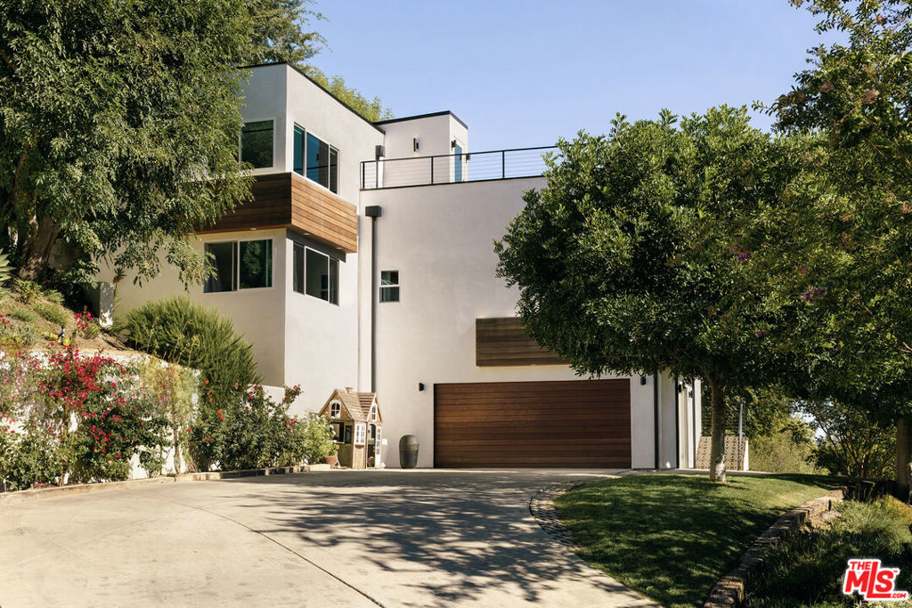 Perched high above Old Agoura, this striking home blends sleek modern architecture with the serene beauty of its natural surroundings, where panoramic views of the Santa Monica Mountains frame a thoughtfully designed, private retreat of laid-back California elegance. A warm blend of Brazilian Ipe wood, smooth stucco, and natural stone sets the stage for contemporary living in harmony with the outdoors. Inside, an open-concept layout, soaring ceilings, and architectural windows invite streaming light, creating a serene and tranquil atmosphere. Additional wonderful outdoor spaces are perfect for sunset dinners, morning coffee, or lively entertaining with family and friends. Spanning more than 3,000 square feet, the home features a dramatic living room with expansive view-facing windows designed to bring the outdoors in. In the huge primary bedroom, you'll love the jaw-dropping picture windows framing views in every direction, and a stunning magazine-worthy spa-style primary bathroom. The wonderful four additional guest rooms are generously sized. The crown jewel is the extraordinary rooftop deck, where you can soak in sweeping views of the Santa Monica Mountains and sunsets you'll never forget. Recent upgrades blend style, function, and comfort, including a brand-new warrantied roof, two newer A/C and heating units, and some updated flooring and carpet. A sophisticated garage conversion showcases brand-new flooring and transforms into a flexible bonus haven featuring a private entrance, direct interior access, and a soundproof booth, an exceptional space for a creative studio, executive office, or stylish guest suite. (Bonus room not counted in square footage.) Just minutes from town yet tucked into a serene rural setting, the property lies within the sought-after award winning Las Virgenes School District. Outdoor enthusiasts will love direct access to hiking, biking, and equestrian trails at nearby Cheesebro National Park with Malibu's beaches only 20 minutes away.